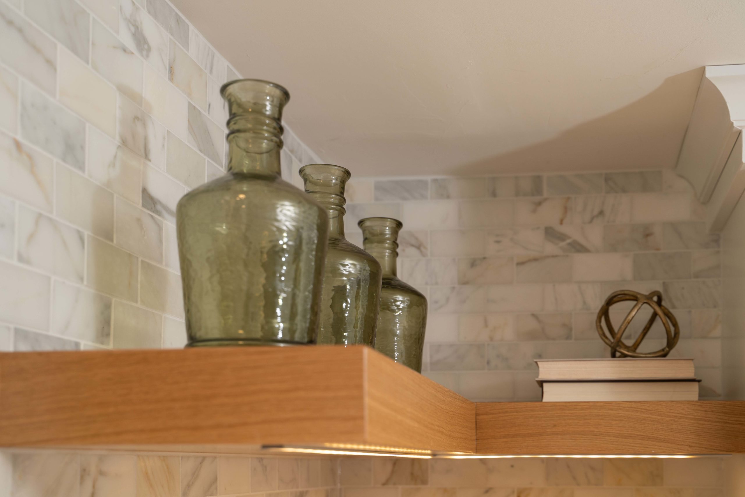 A shelf with two vases and a book on it, perfect for your kitchen remodel.