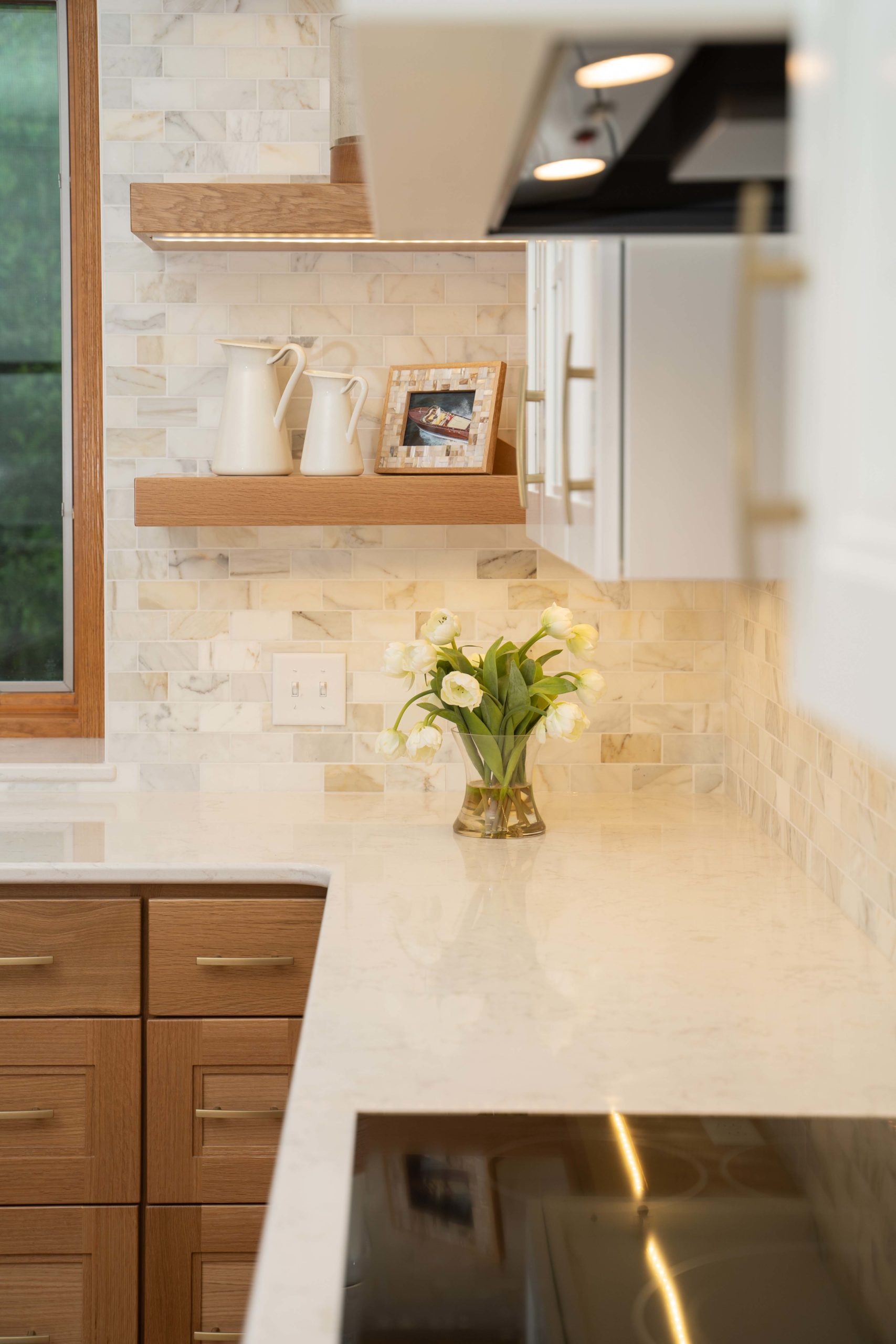 A white kitchen with a wooden counter top that has undergone a kitchen remodel.