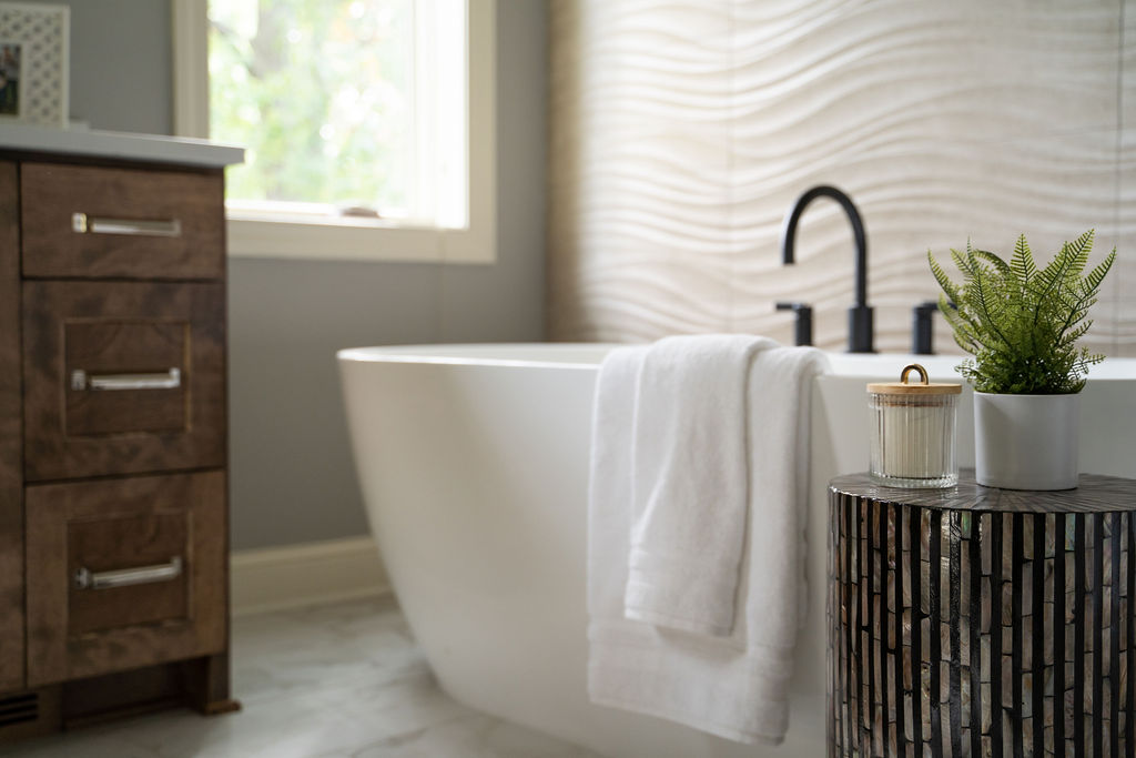 An Edina remodel with a bathroom featuring a tub and a plant on a table.