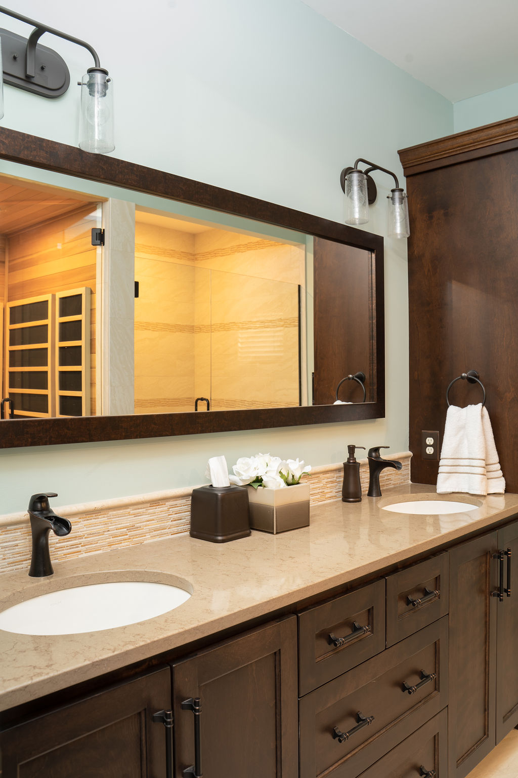 A modern Edina remodel that features a spacious bathroom with two sinks and a large mirror.