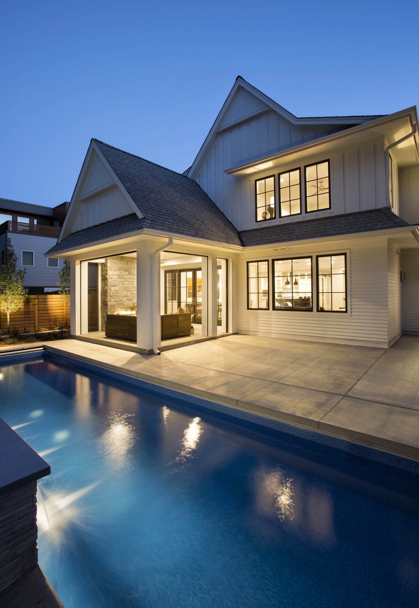 A modern home with a swimming pool at dusk.