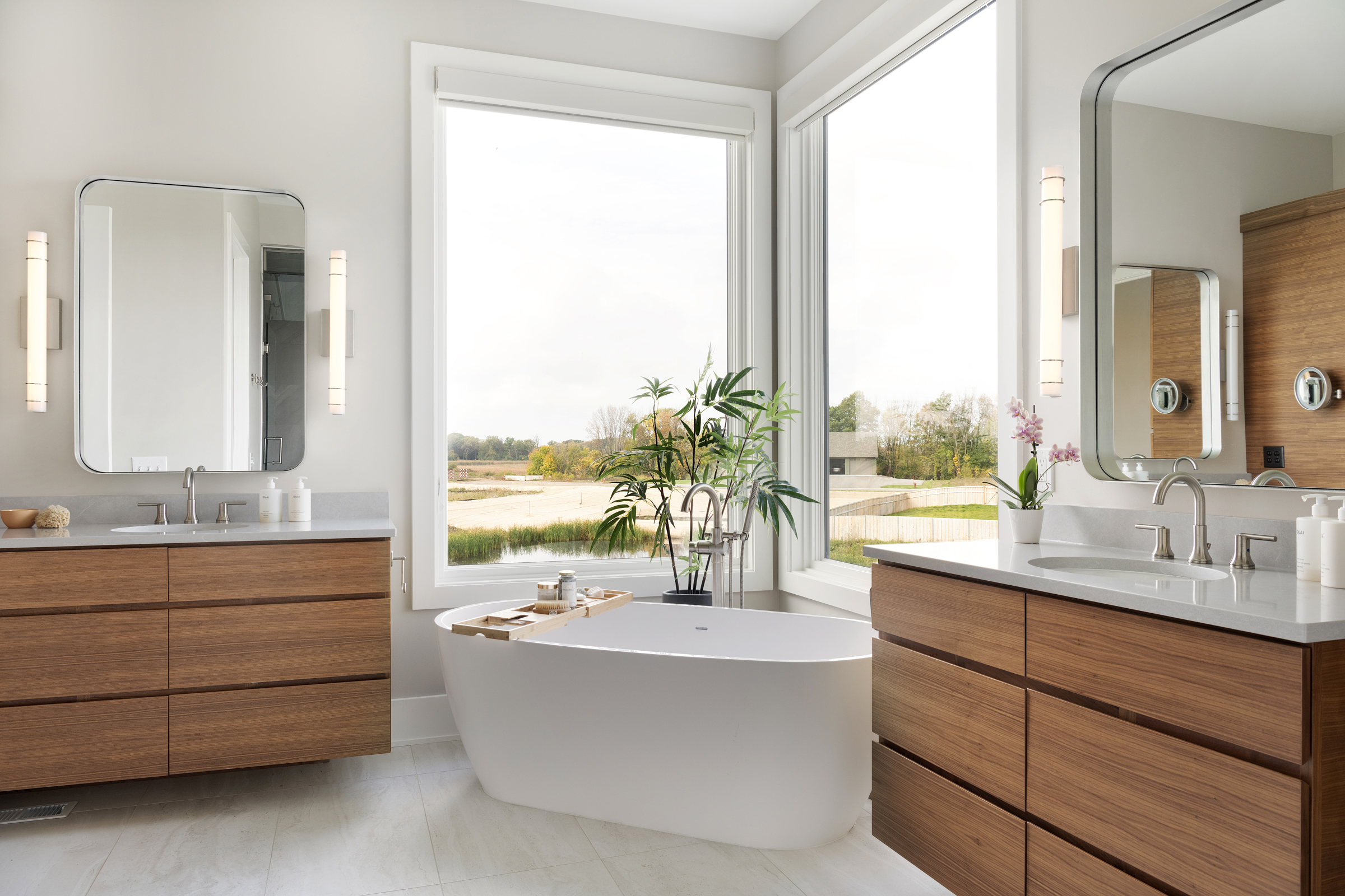 A modern bathroom with wooden cabinets and a large window.