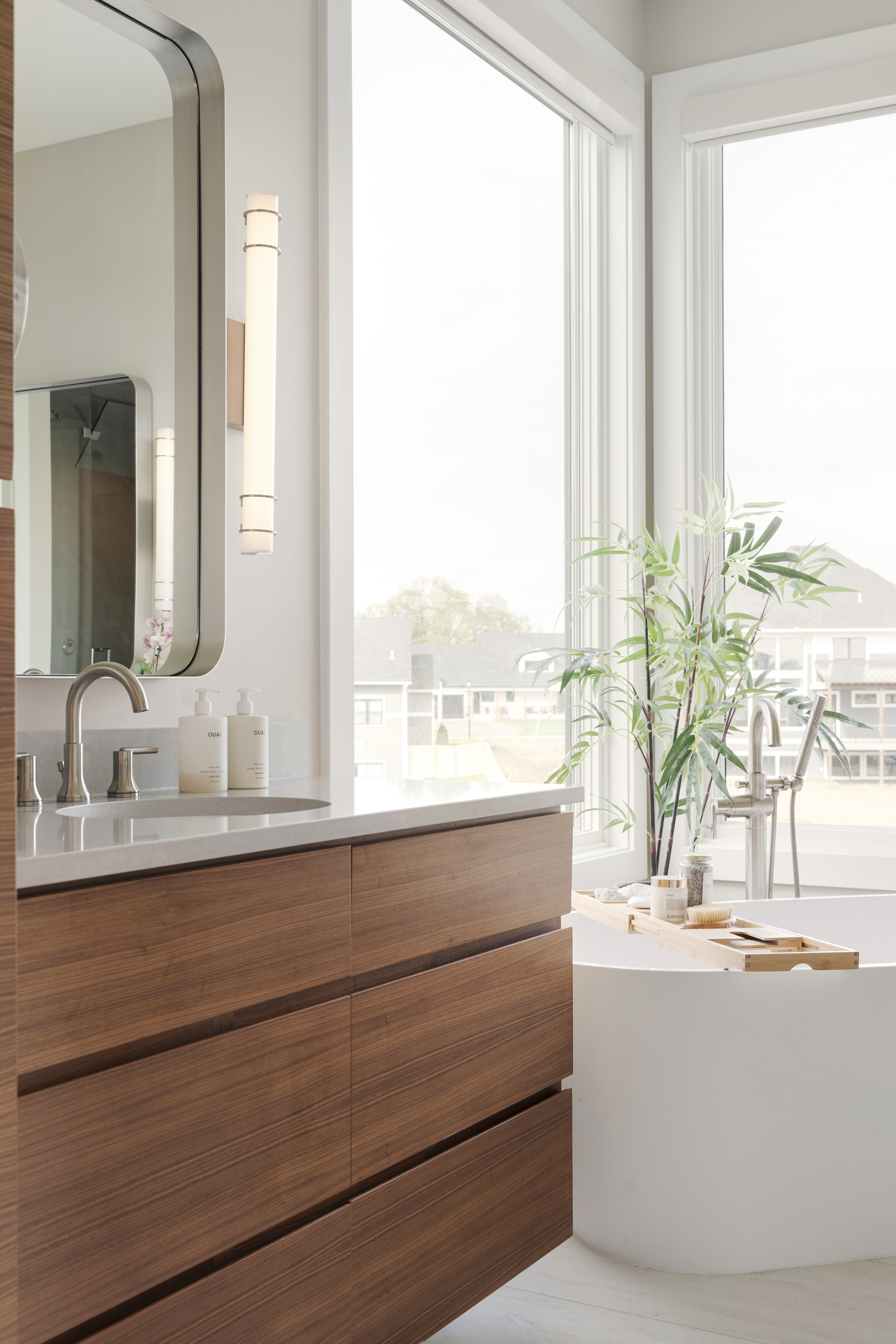 A modern bathroom with wooden cabinets and a large window.