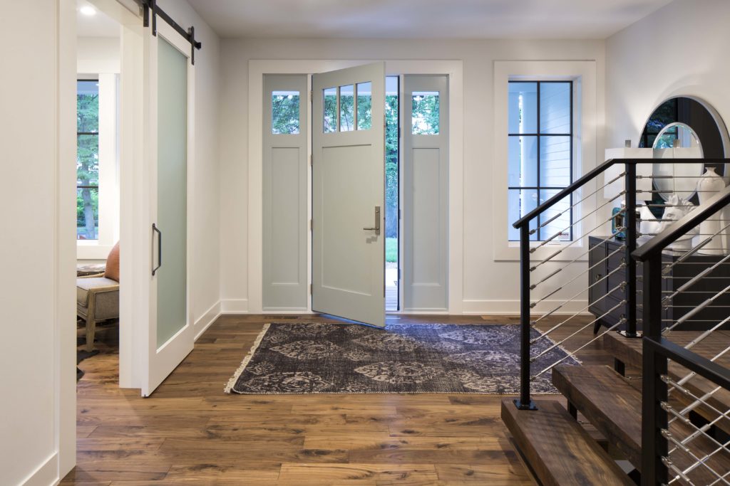 An entryway with hardwood floors and a glass door.