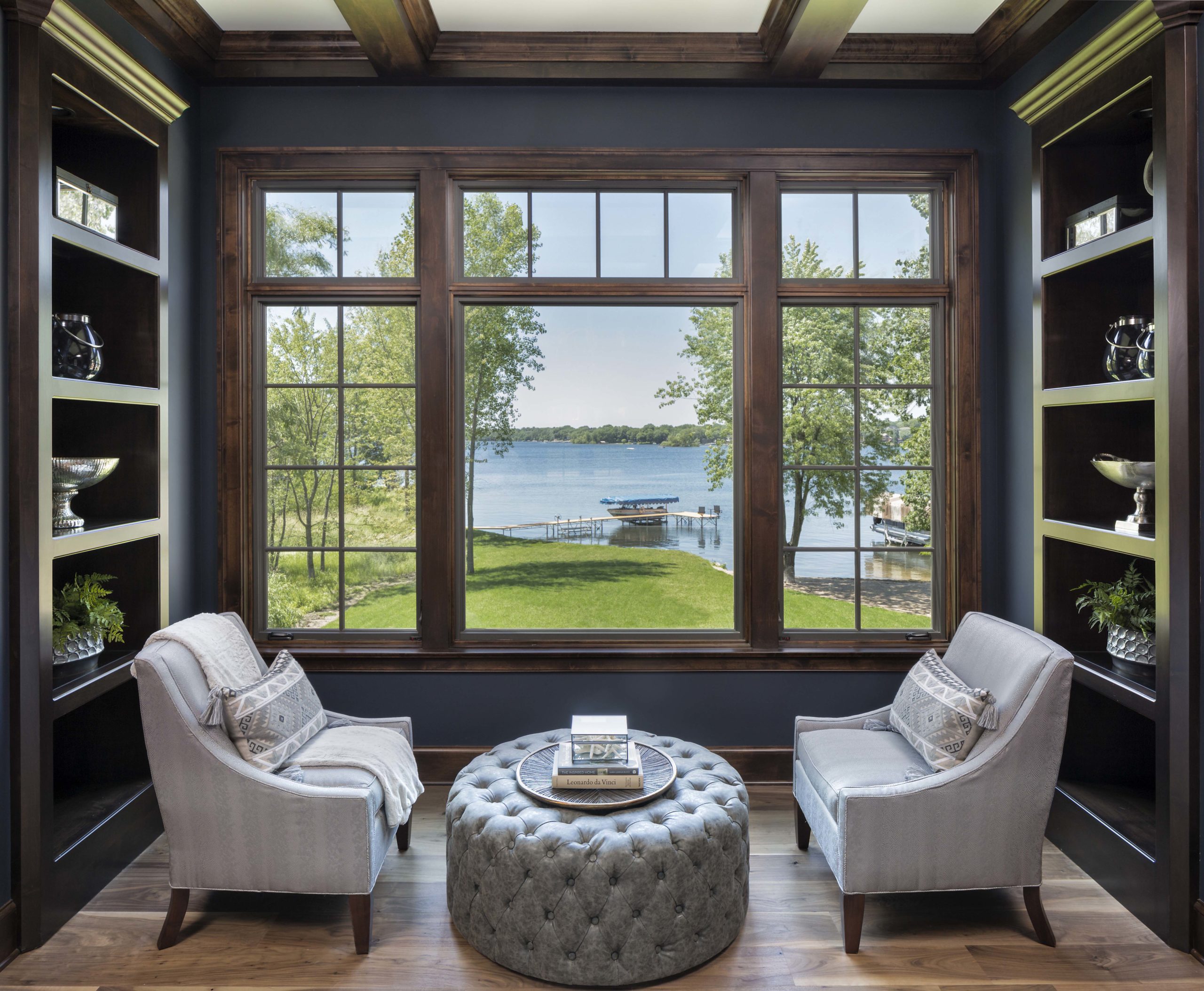 A living room with a large window overlooking a lake.