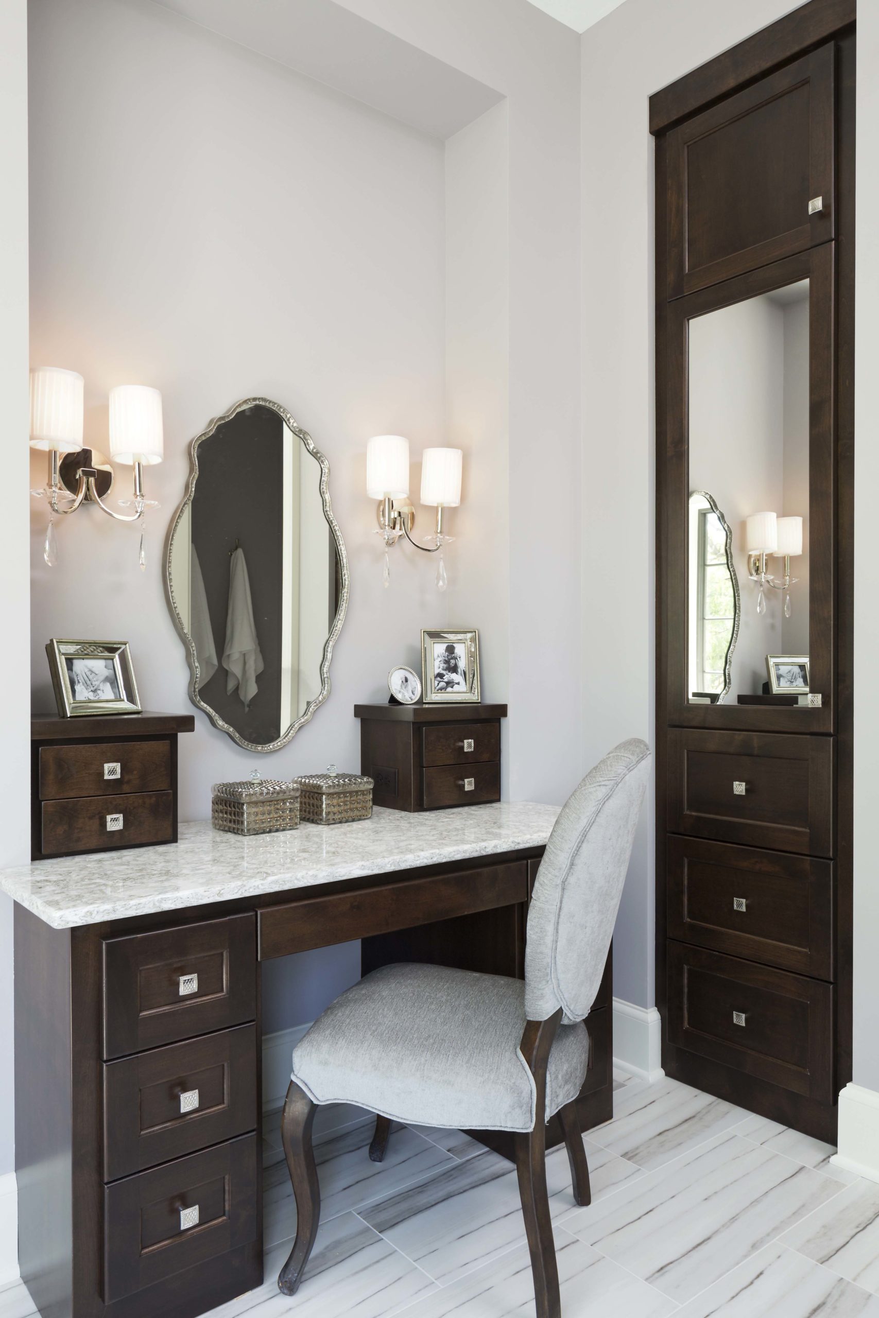 A bathroom with a vanity, mirror, and chair.