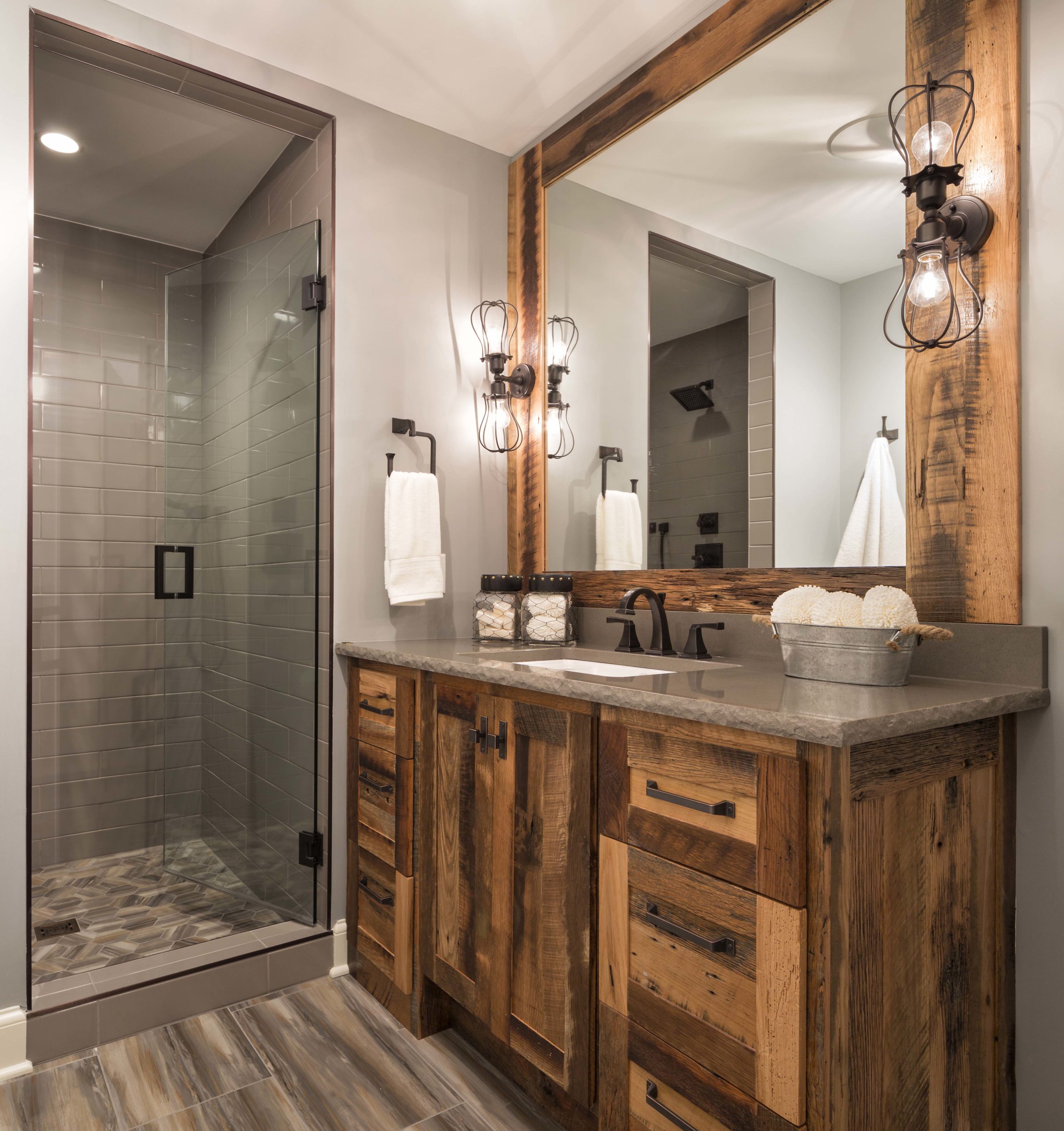 A bathroom with a wooden vanity and a glass shower.