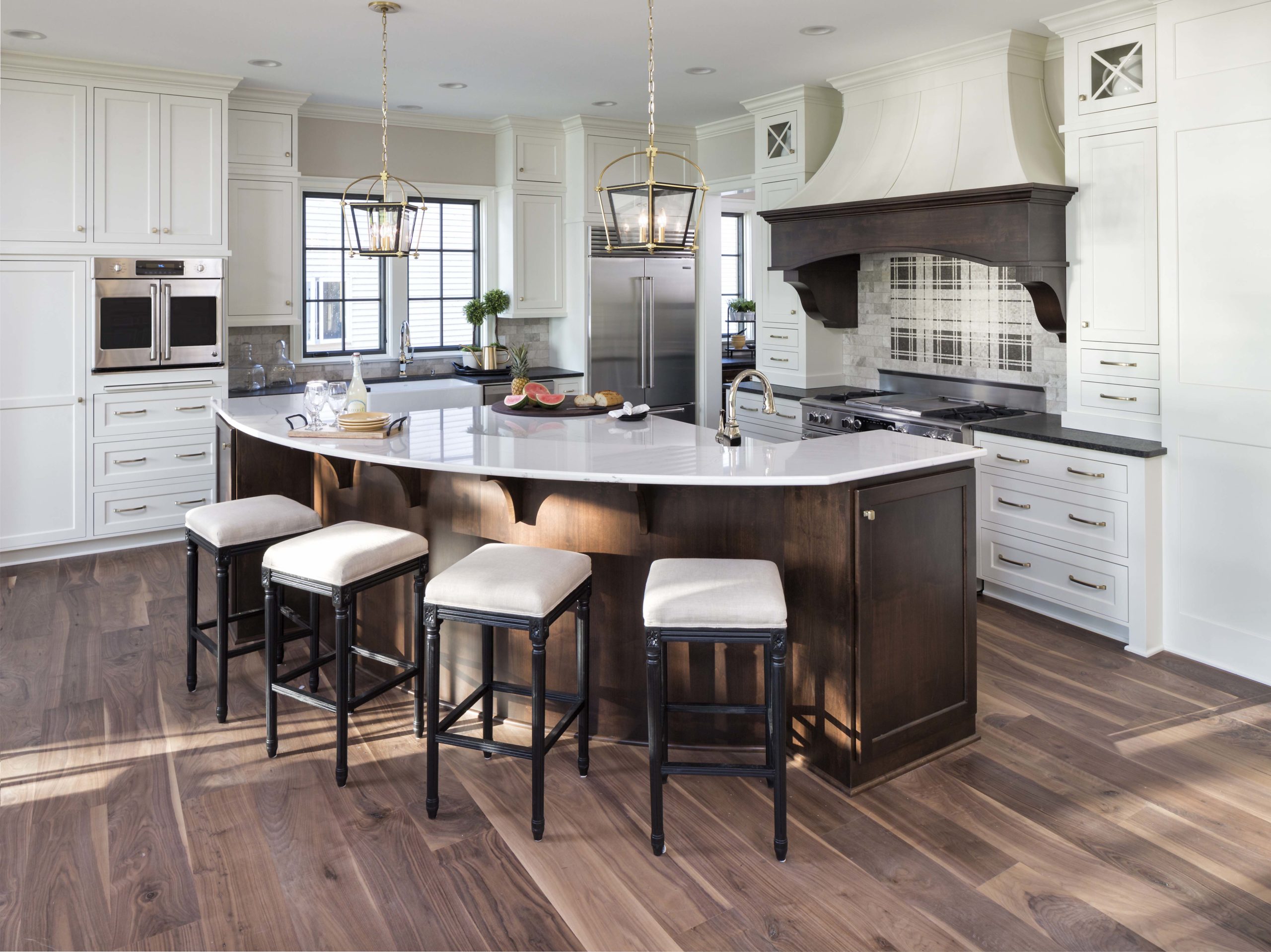 A large kitchen with a center island and bar stools.
