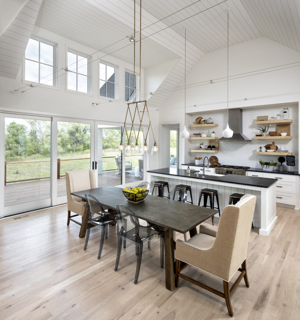 A large kitchen with hardwood floors and a dining table.