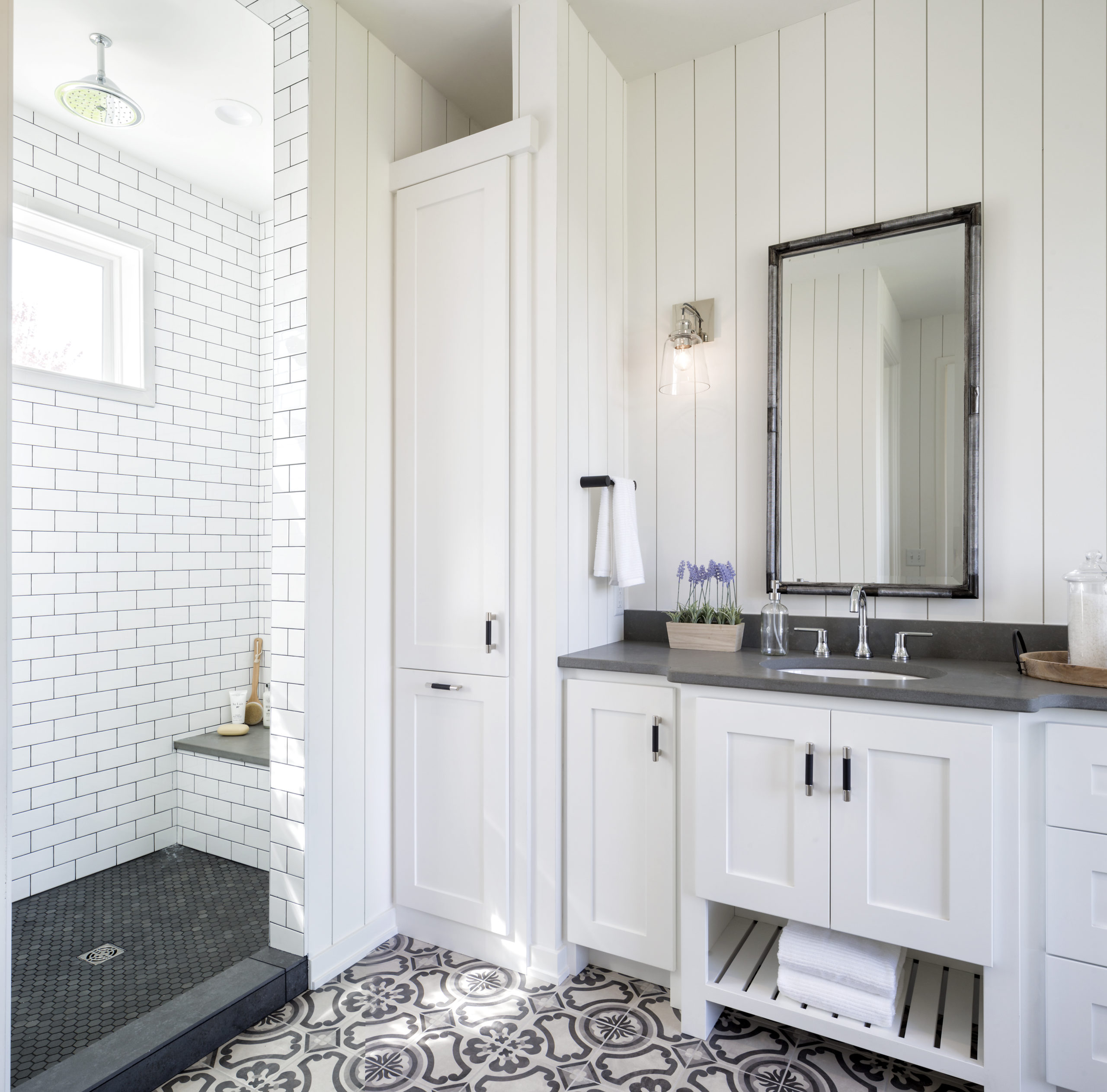 A white and black bathroom with a tiled floor.