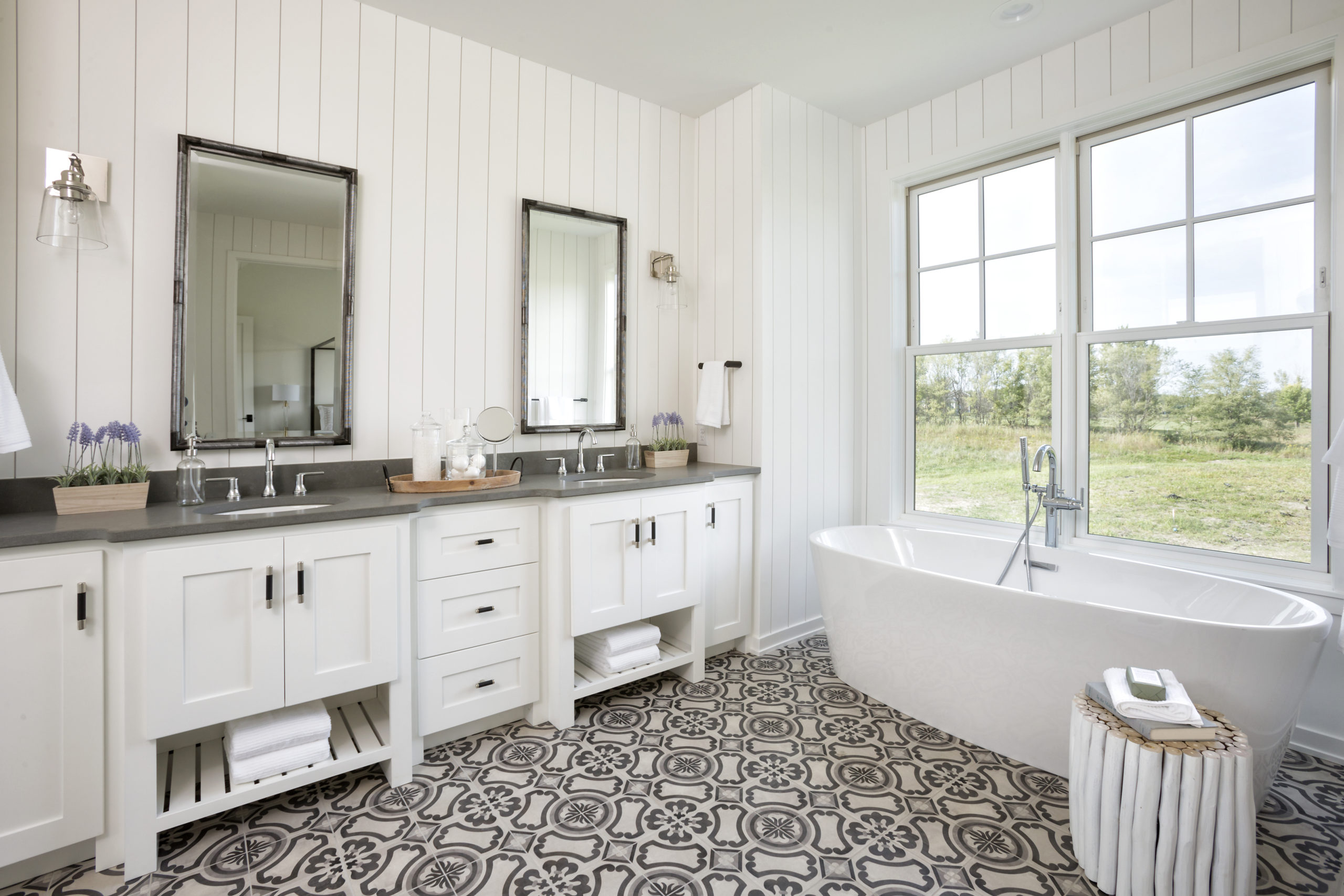 A white bathroom with a black and white tile floor.