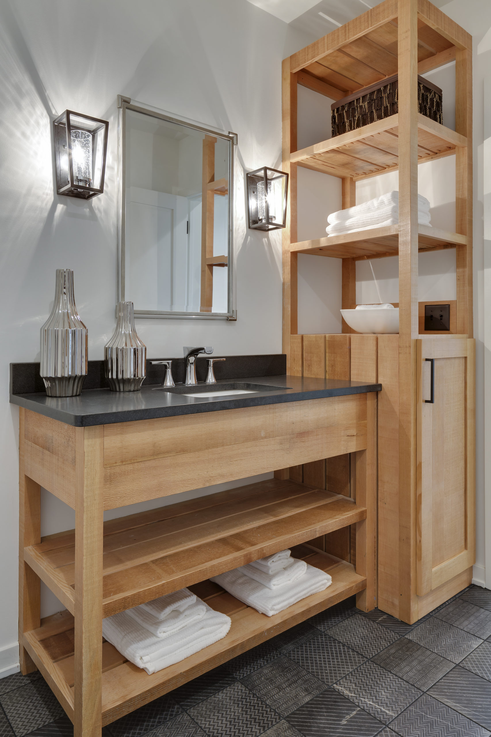 A bathroom with wooden shelves and towels.