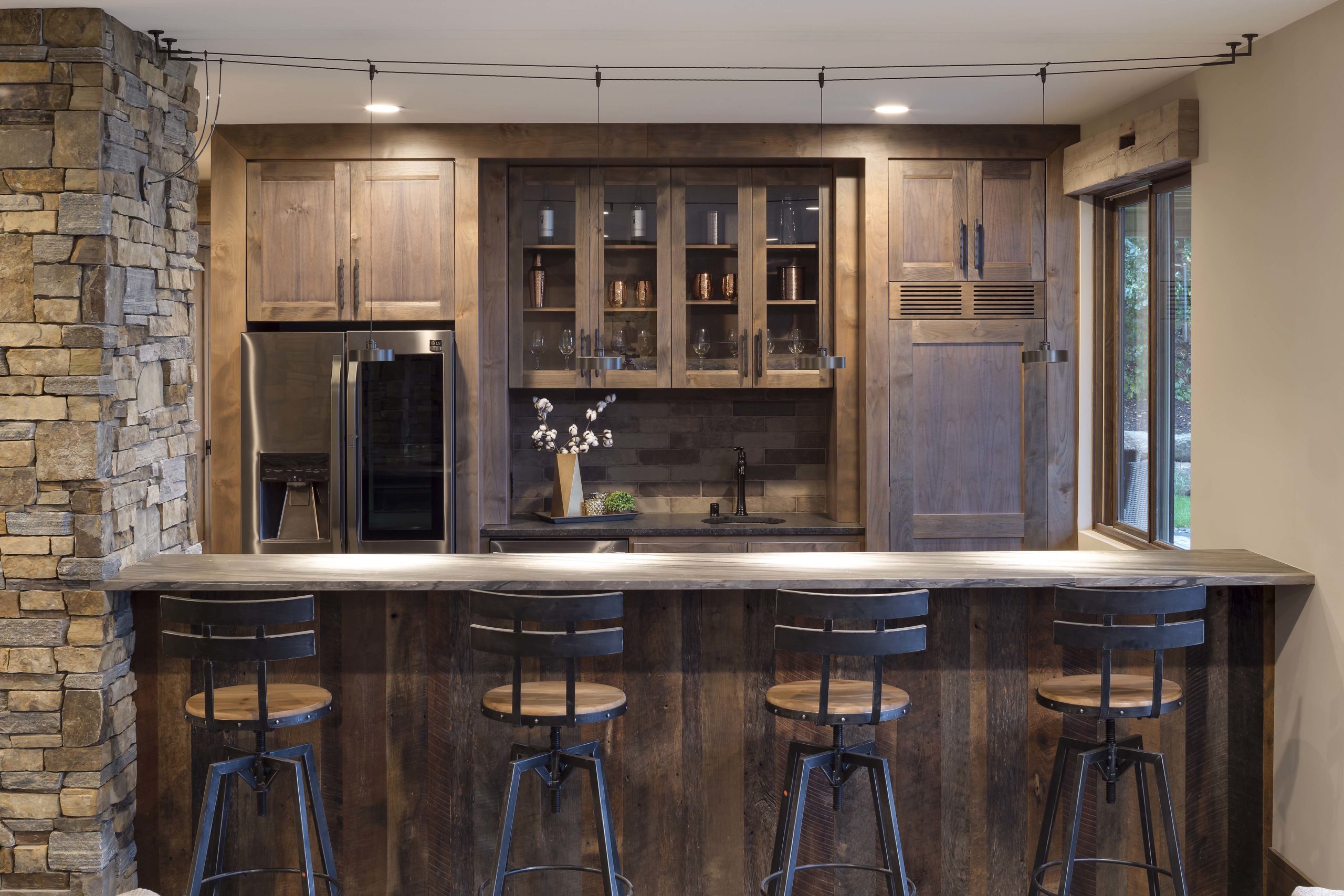 A rustic kitchen with a bar and stools.