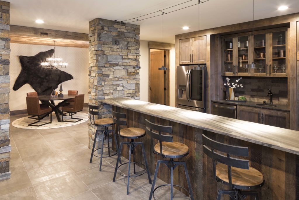 A home bar with a stone wall and stools.