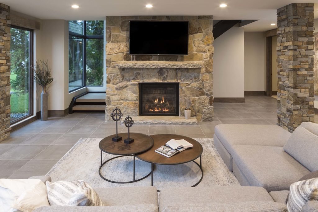A modern living room with a stone fireplace.