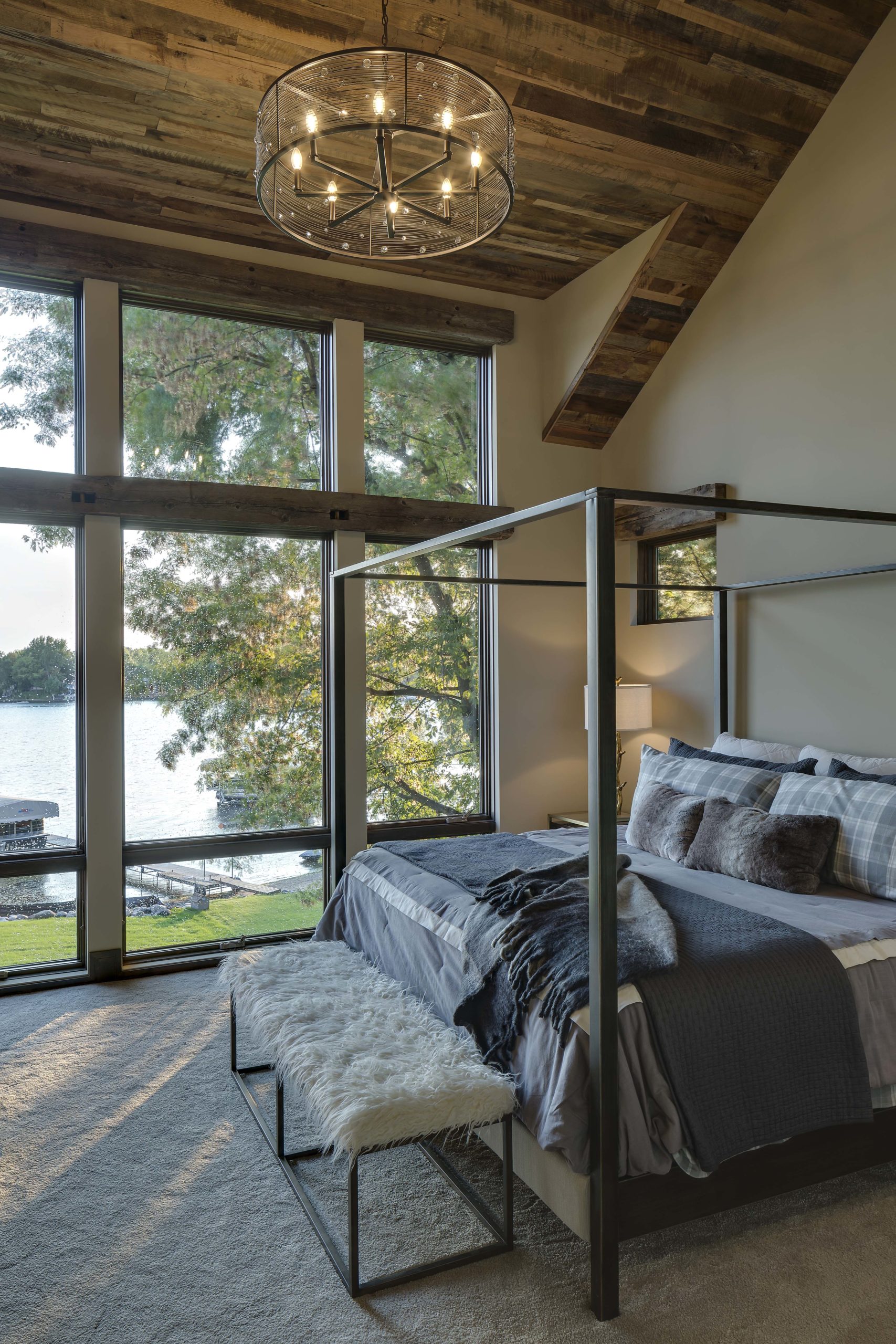 A bedroom with a four poster bed and a view of the lake.