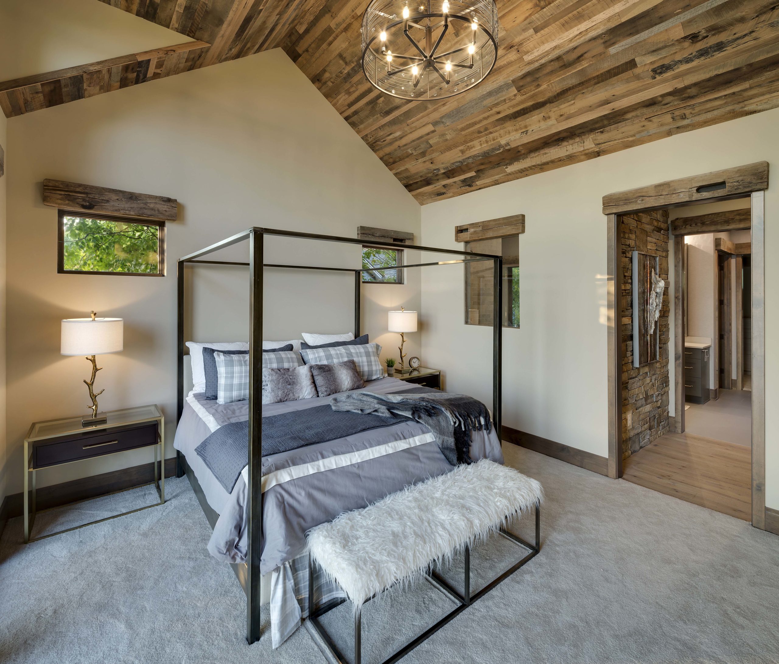 A bedroom with a wood ceiling and a bed.