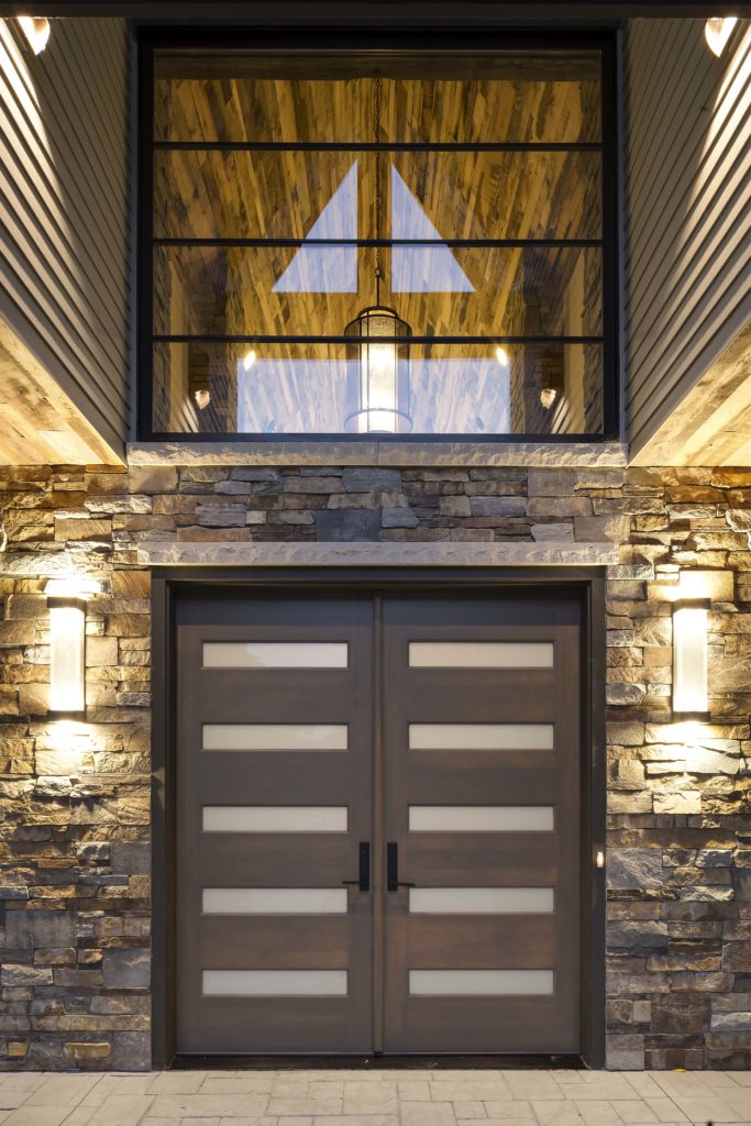 A modern front door with a stone wall.