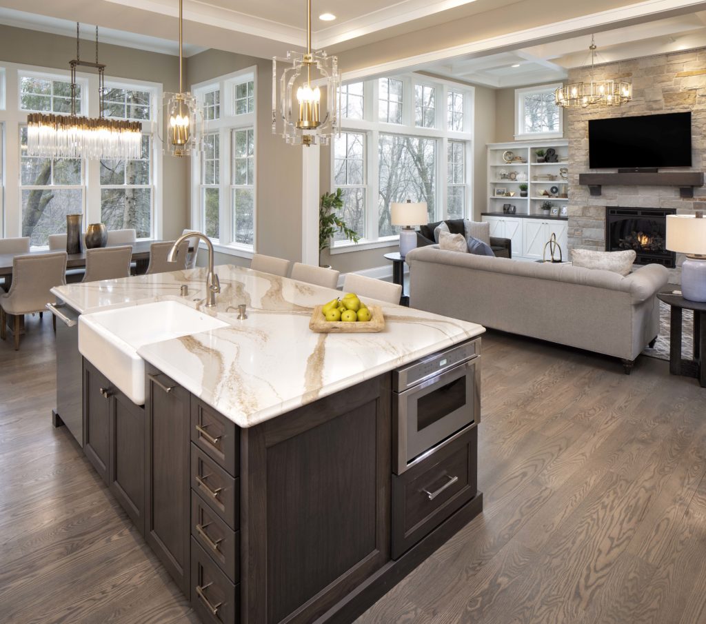 A large kitchen with a marble island and hardwood floors.