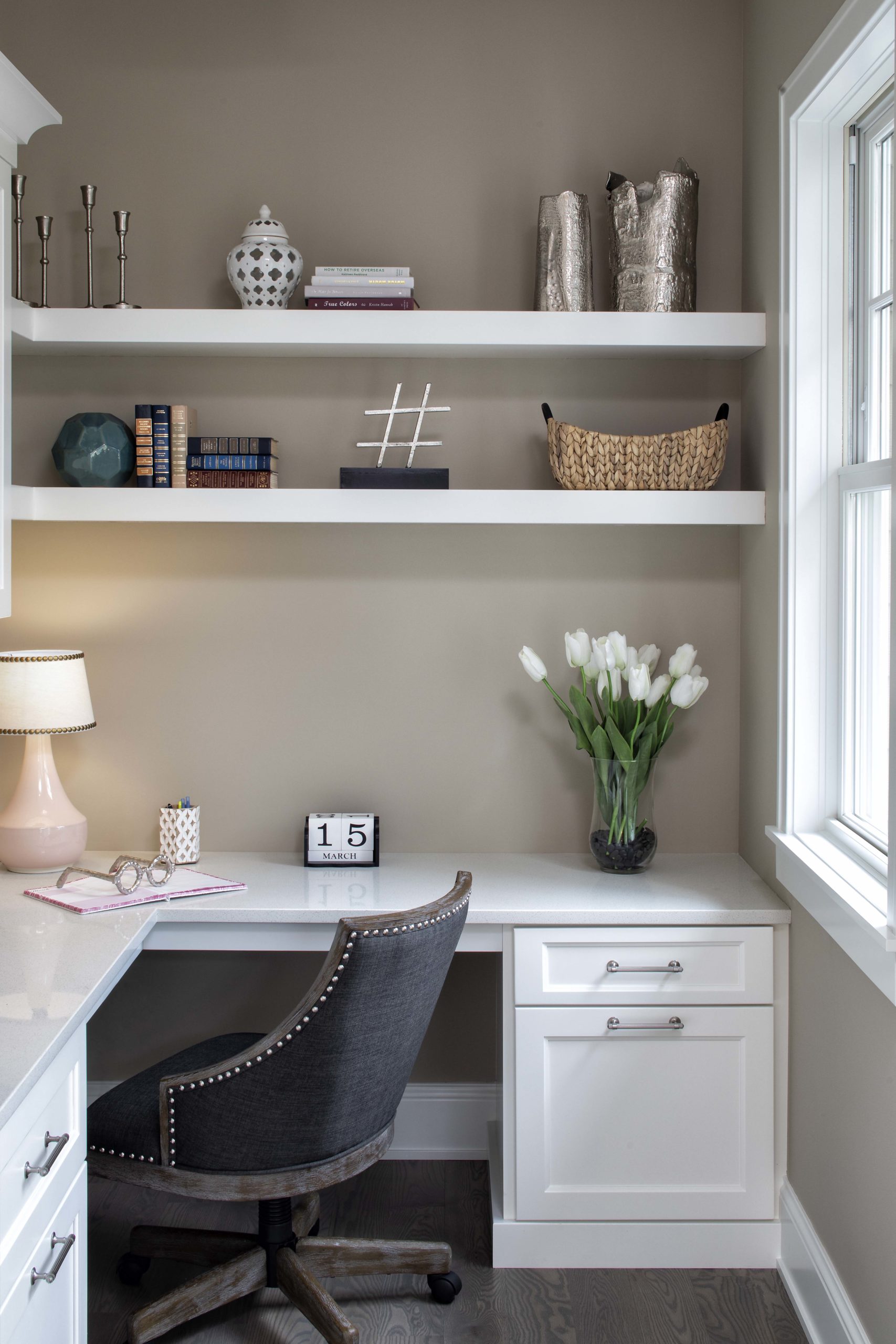 A white home office with shelves and a chair.