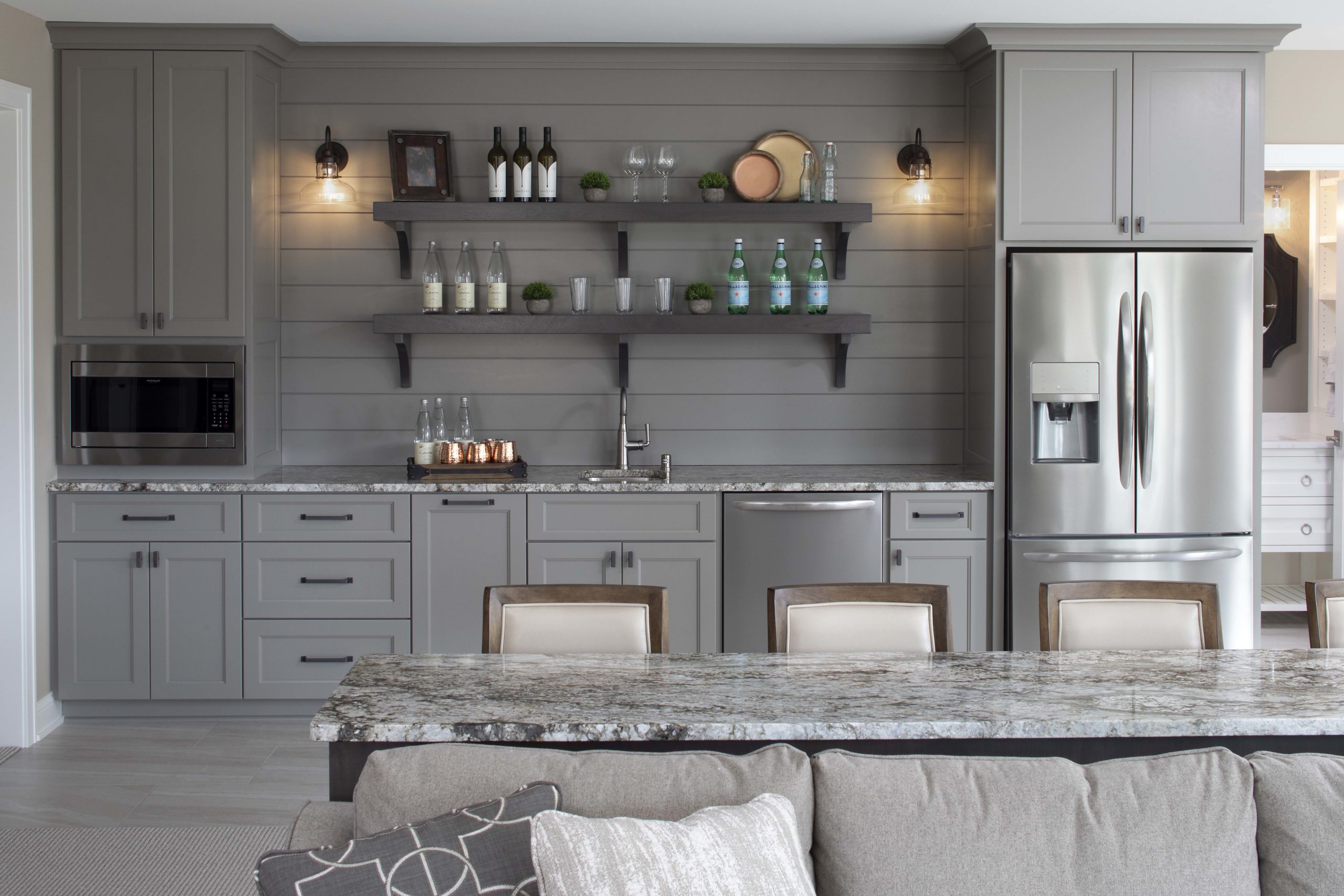 A kitchen with gray cabinets and stainless steel appliances.