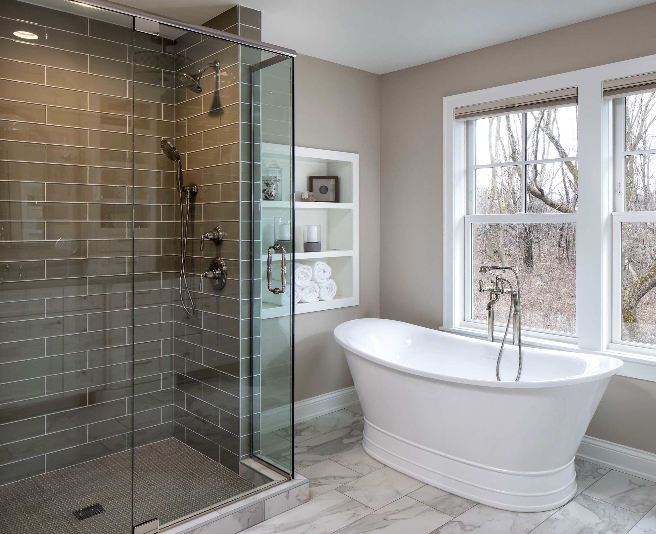 A bathroom with a glass shower and a large tub.