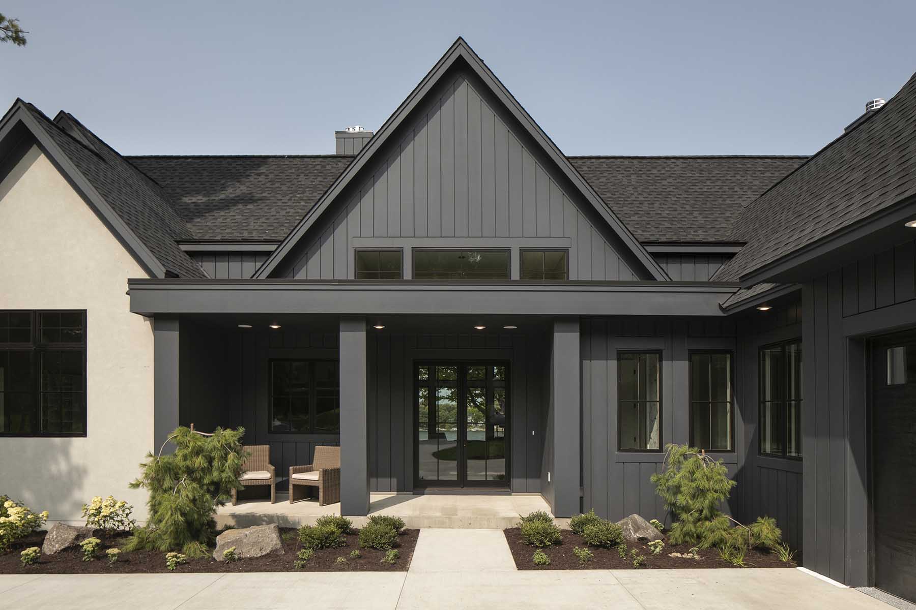 The exterior of a home with black siding and a black door.