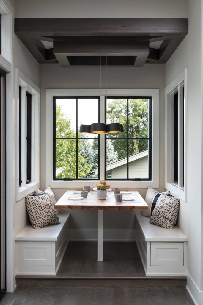 A dining room with a bench and a window.