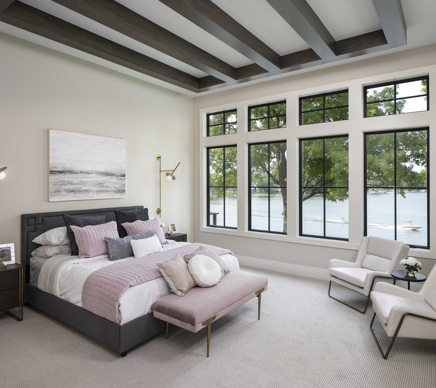 A bedroom with large windows and a bed.