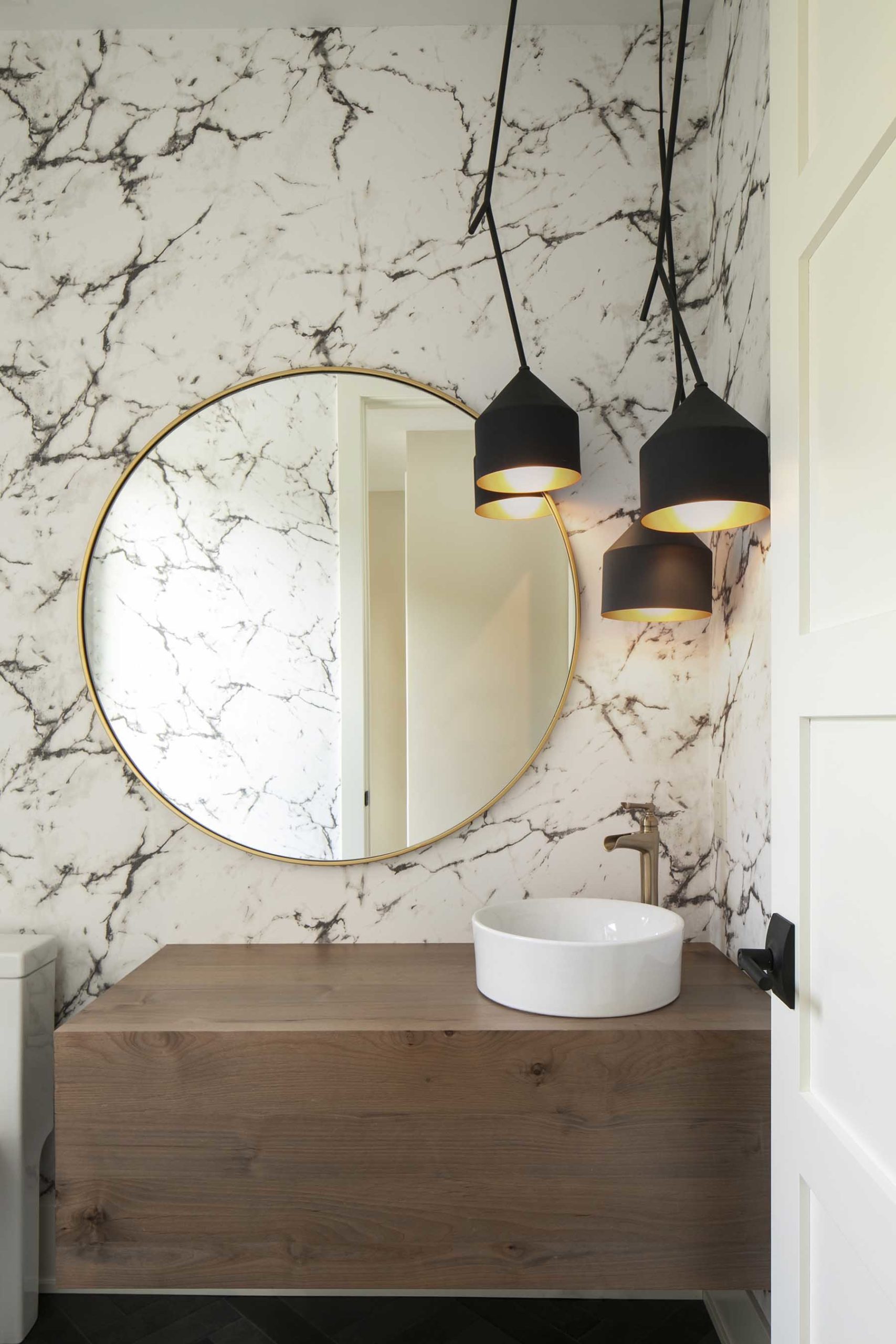 A bathroom with marble walls and a wooden vanity.