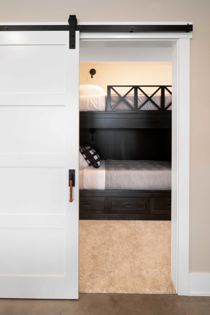 A sliding barn door in a bedroom with a bunk bed.