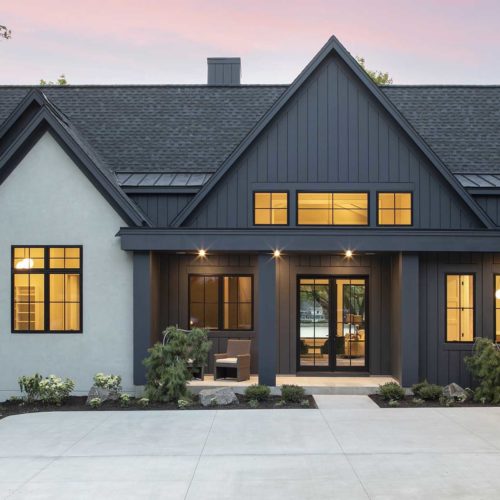 A home with a black exterior and garage door.