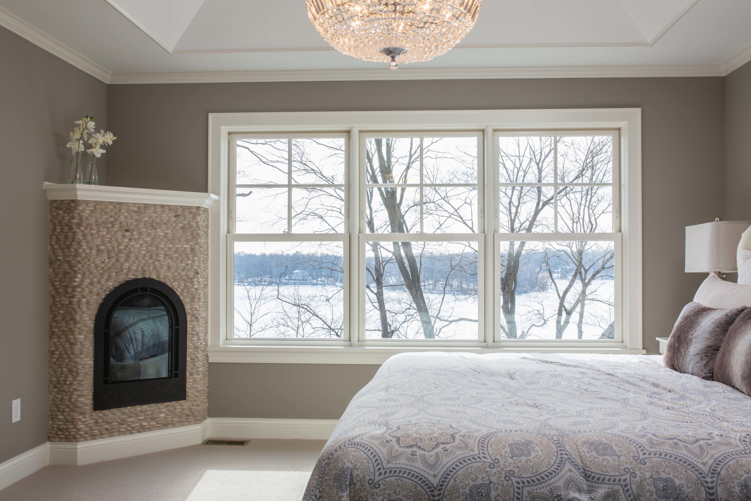 A bedroom with a fireplace and a window.