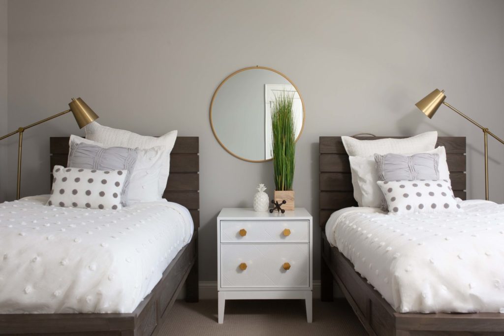 A bedroom with two beds and a dresser.