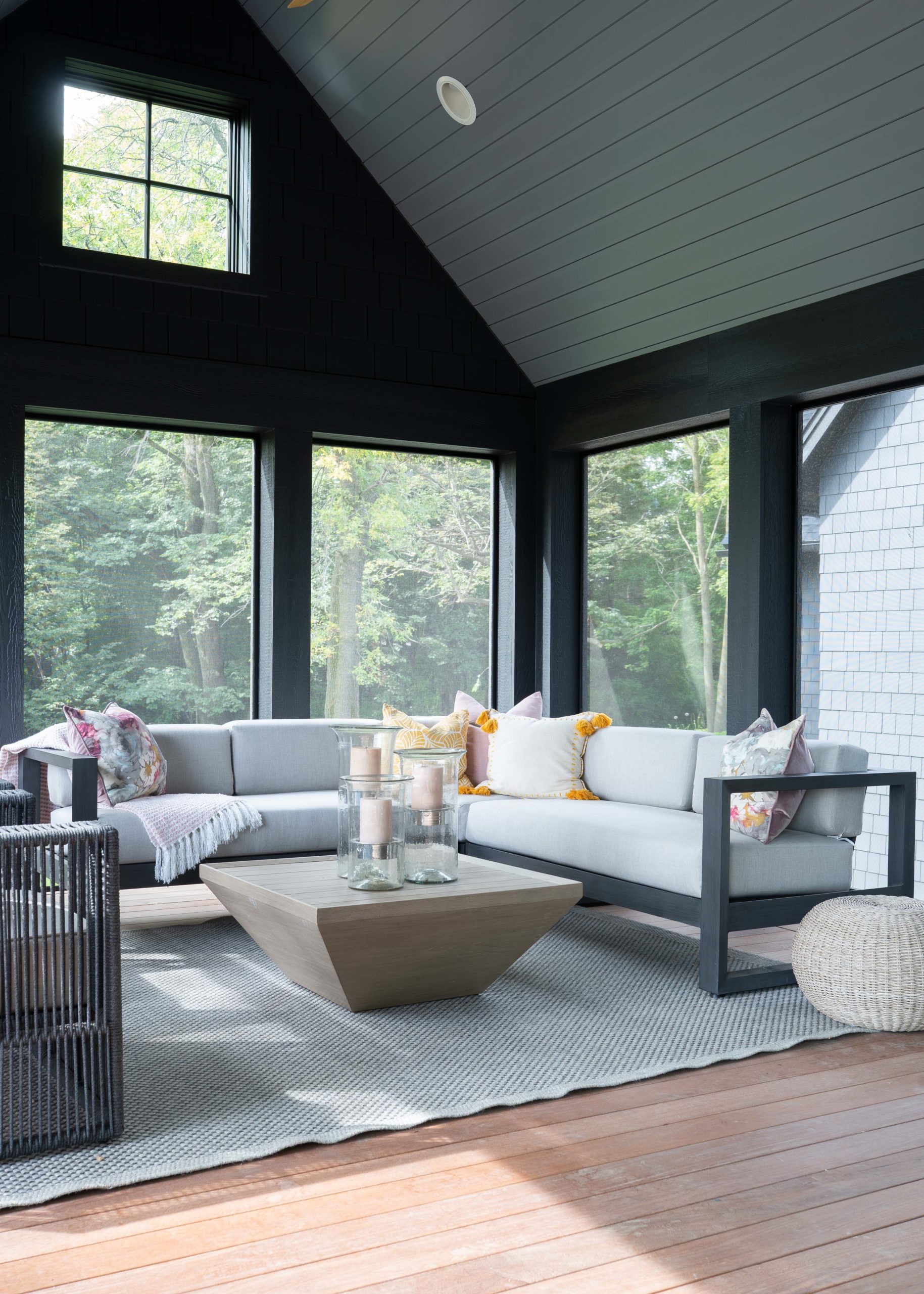 A black and gray living room with a table and chairs.