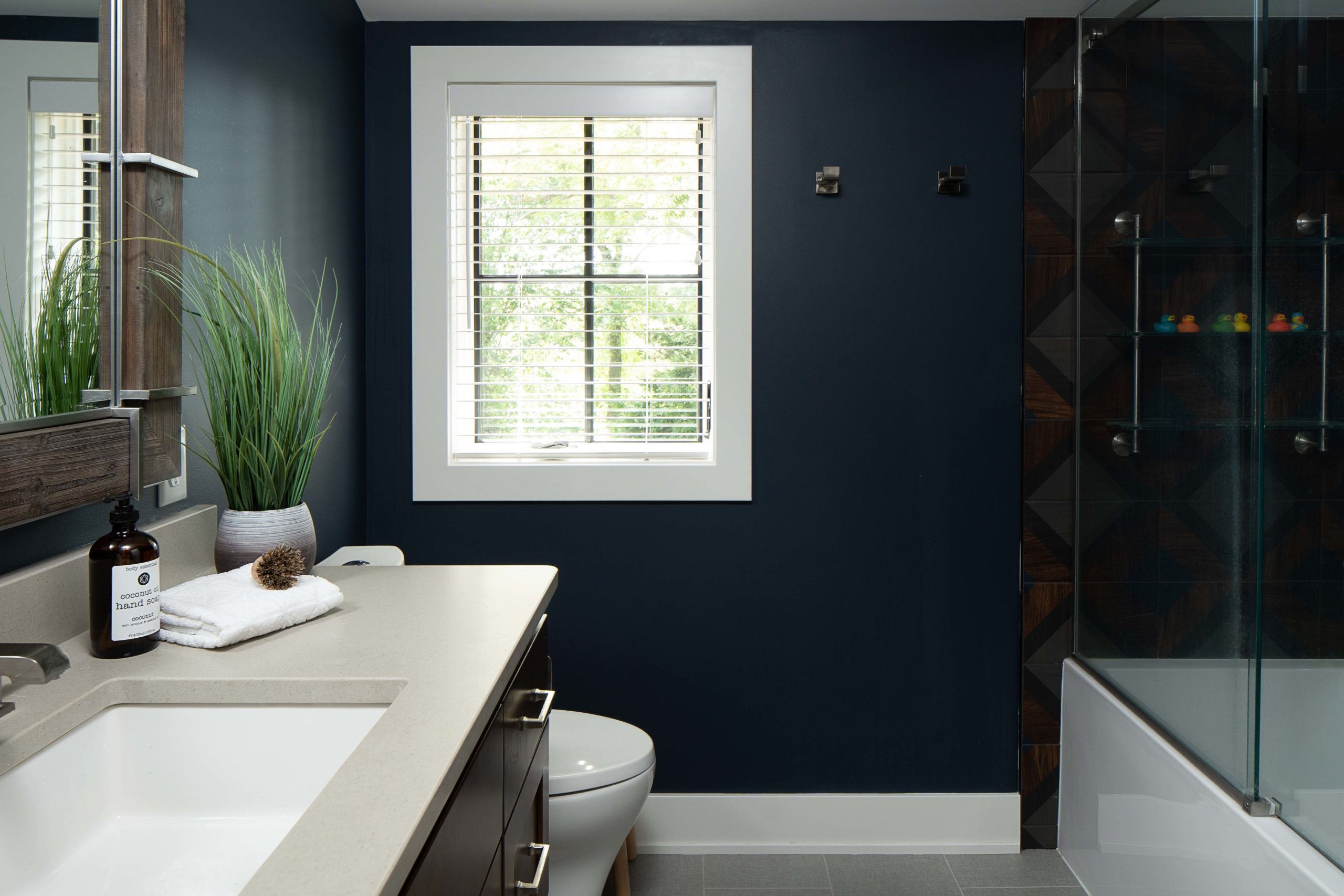 A bathroom with dark blue walls and a toilet.