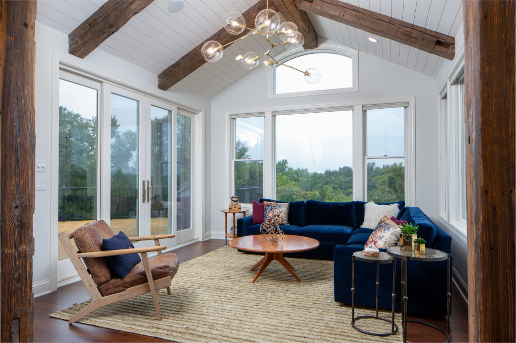 A living room with wooden beams and a blue couch.