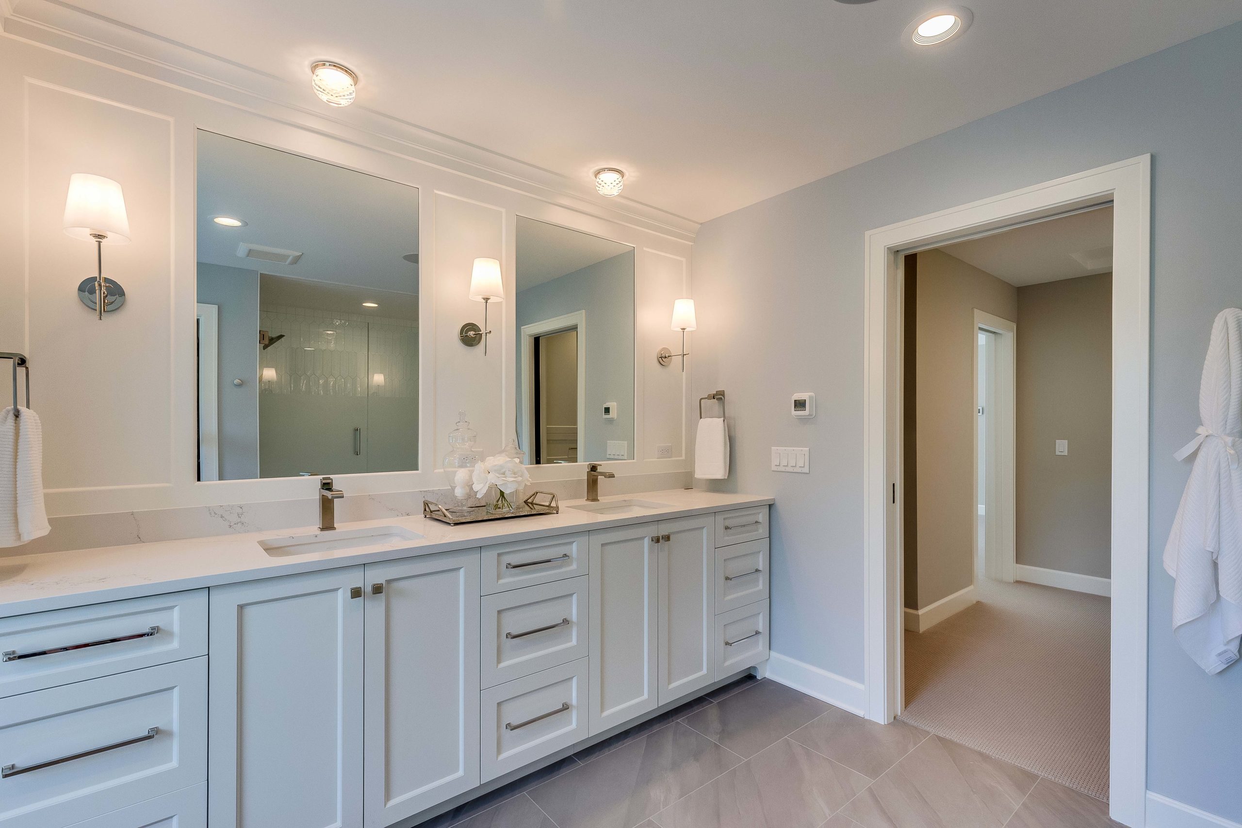 A white bathroom with two sinks and a mirror.