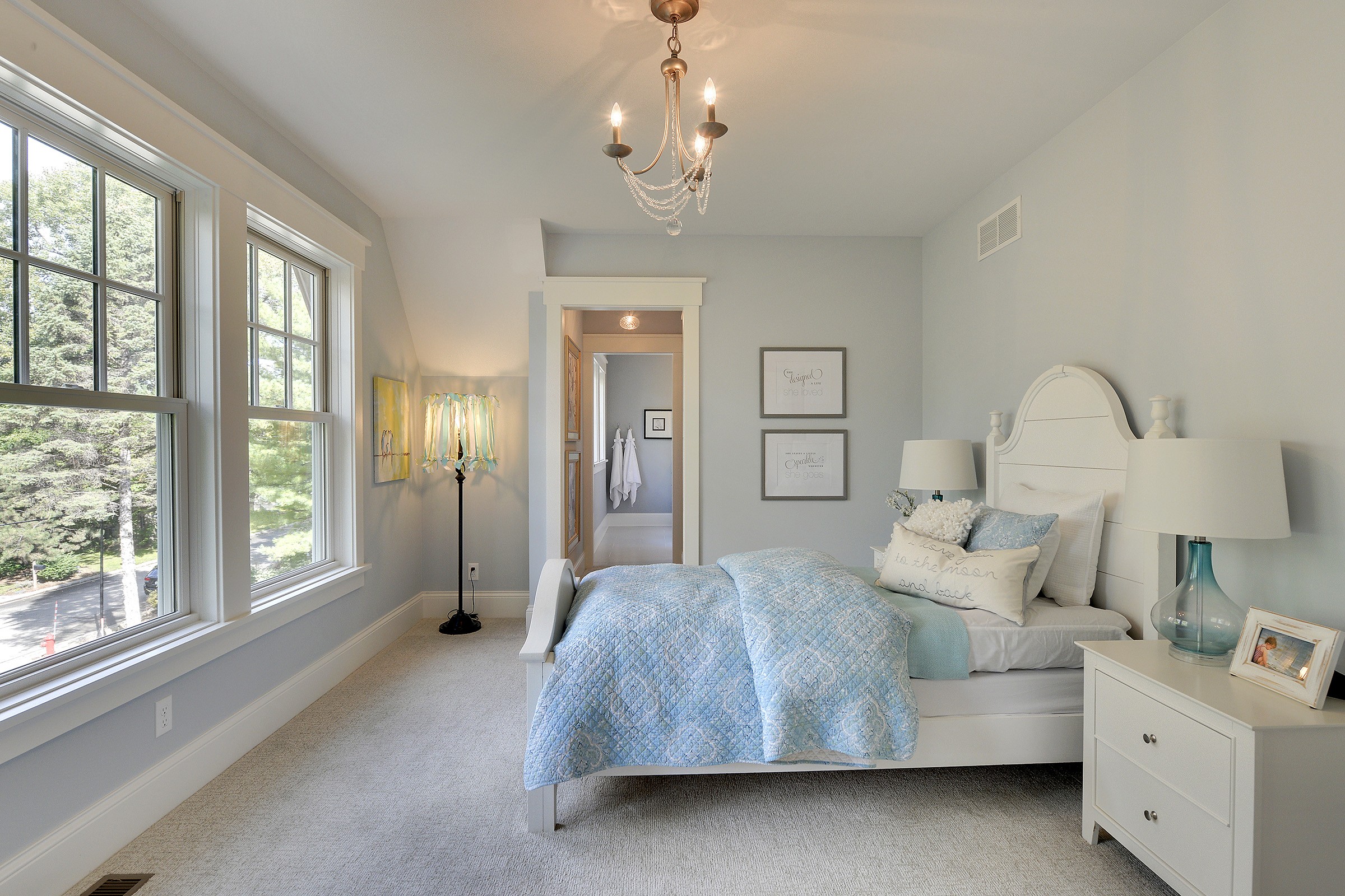 Pastel blue bedroom with white trim and furniture, elegant blue glass lighting and decorations.
