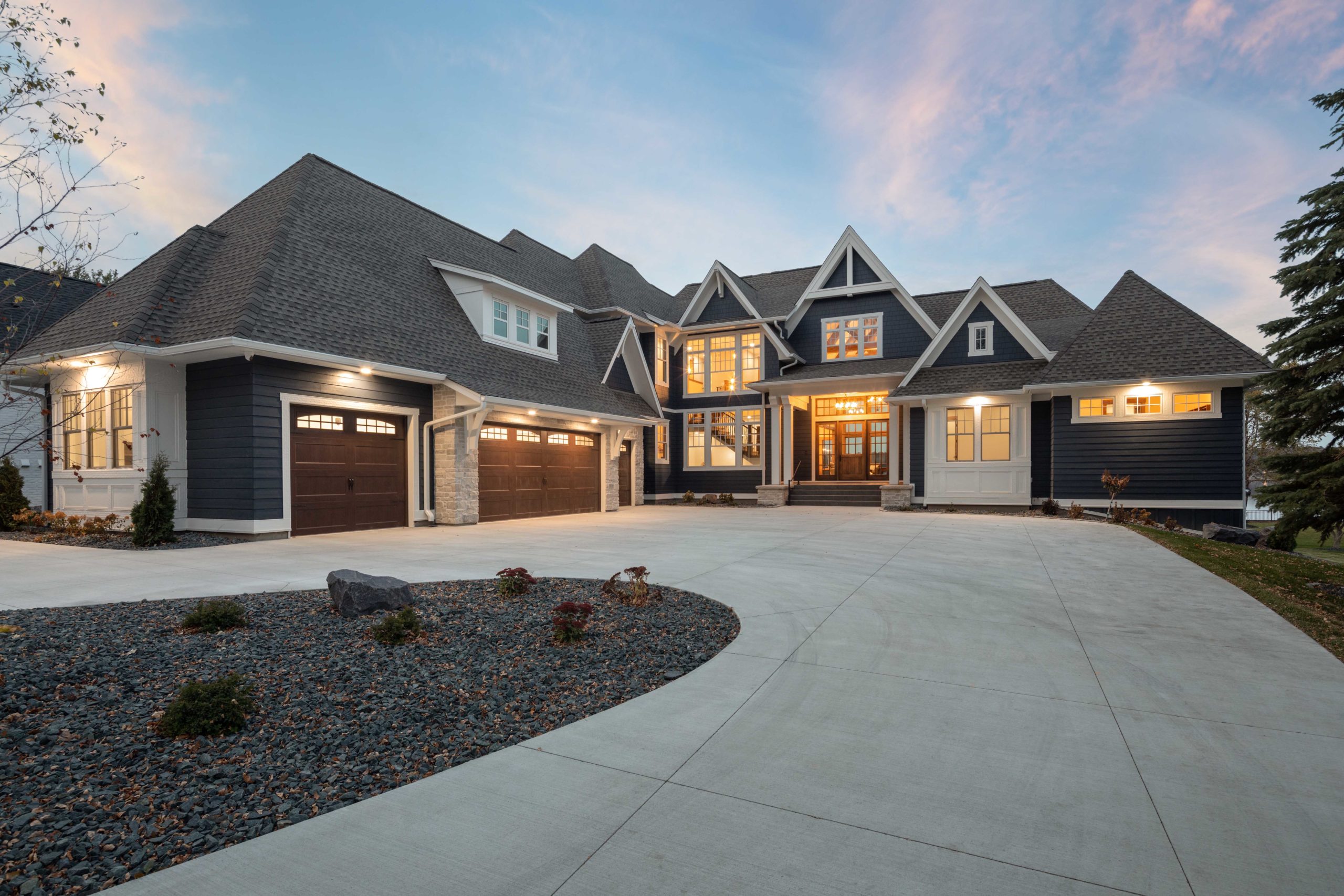 Explore home exterior design ideas for a large home with a driveway and garage.