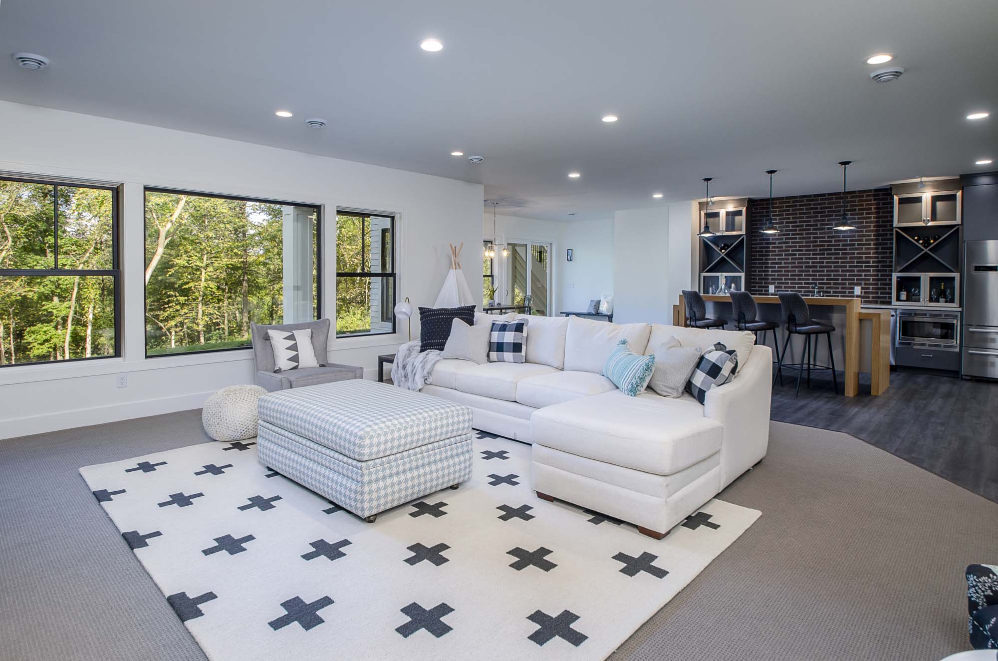 A living room with a white couch and black rug.
