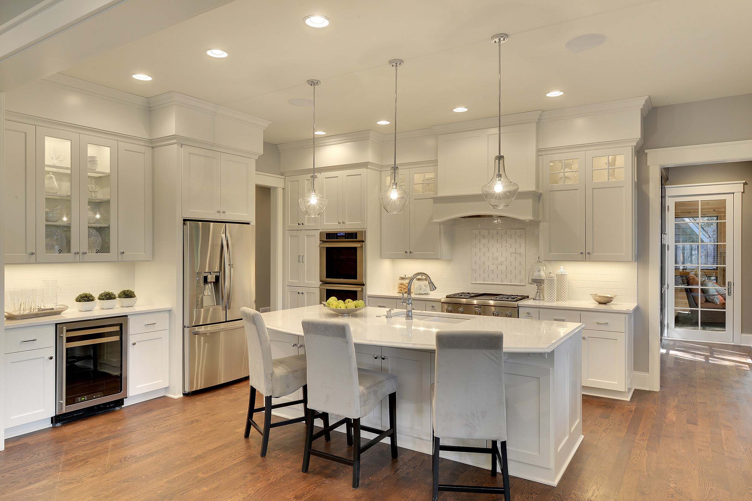 A spacious kitchen fitted with white cabinets and a center island.