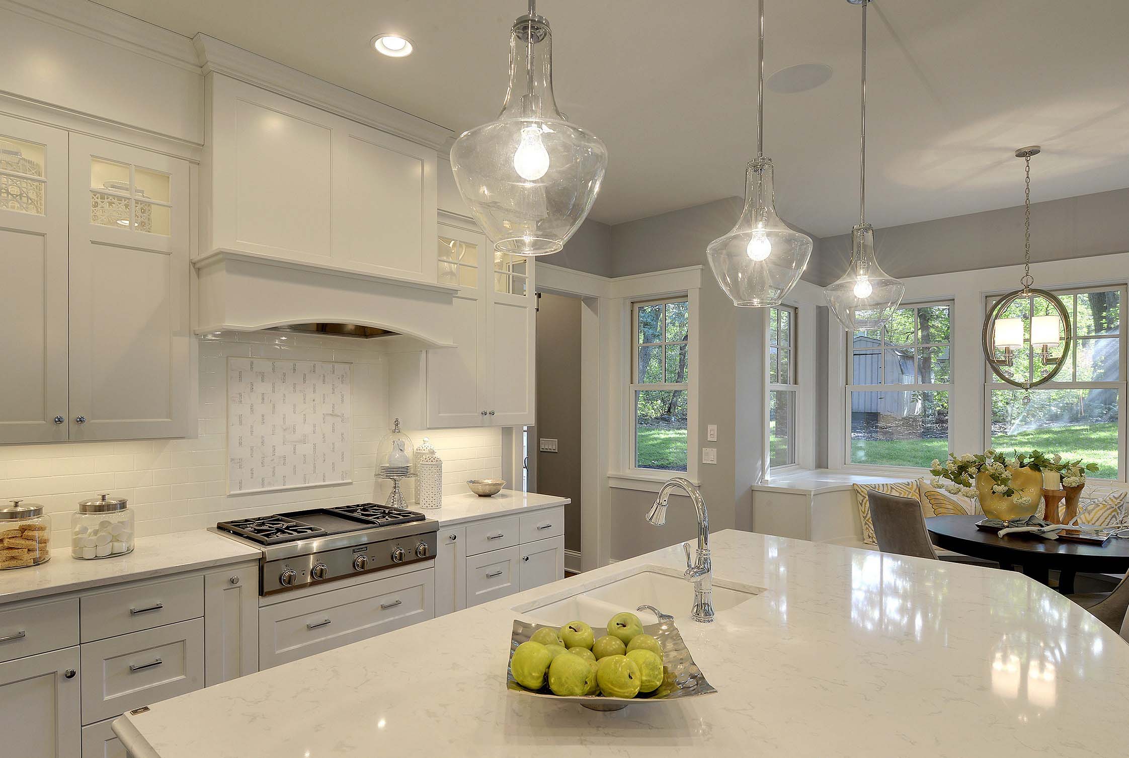 A spacious kitchen with white counter tops and a large center island.