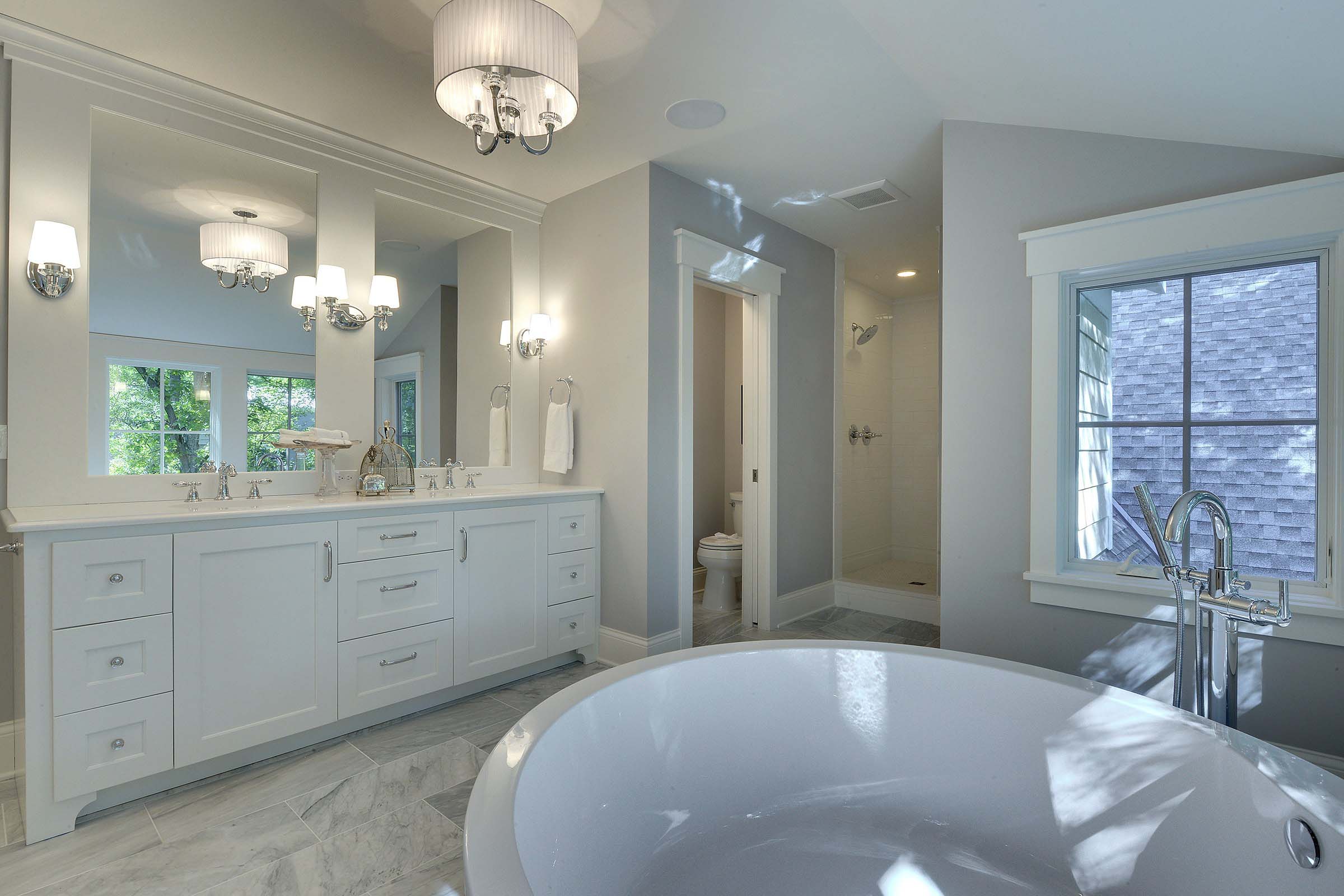 A white bathroom with a large tub and sink.