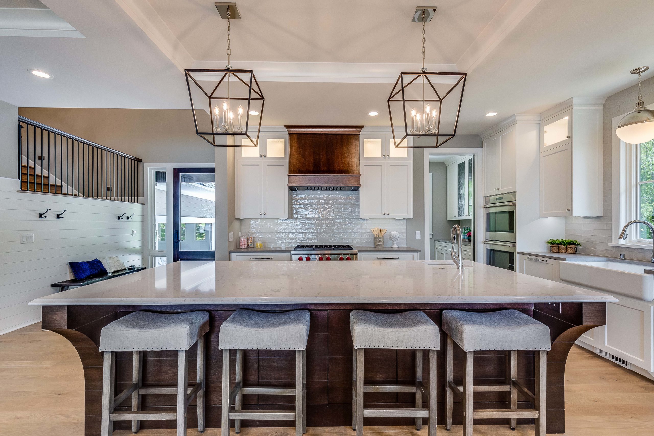 A kitchen with a large island and stools.