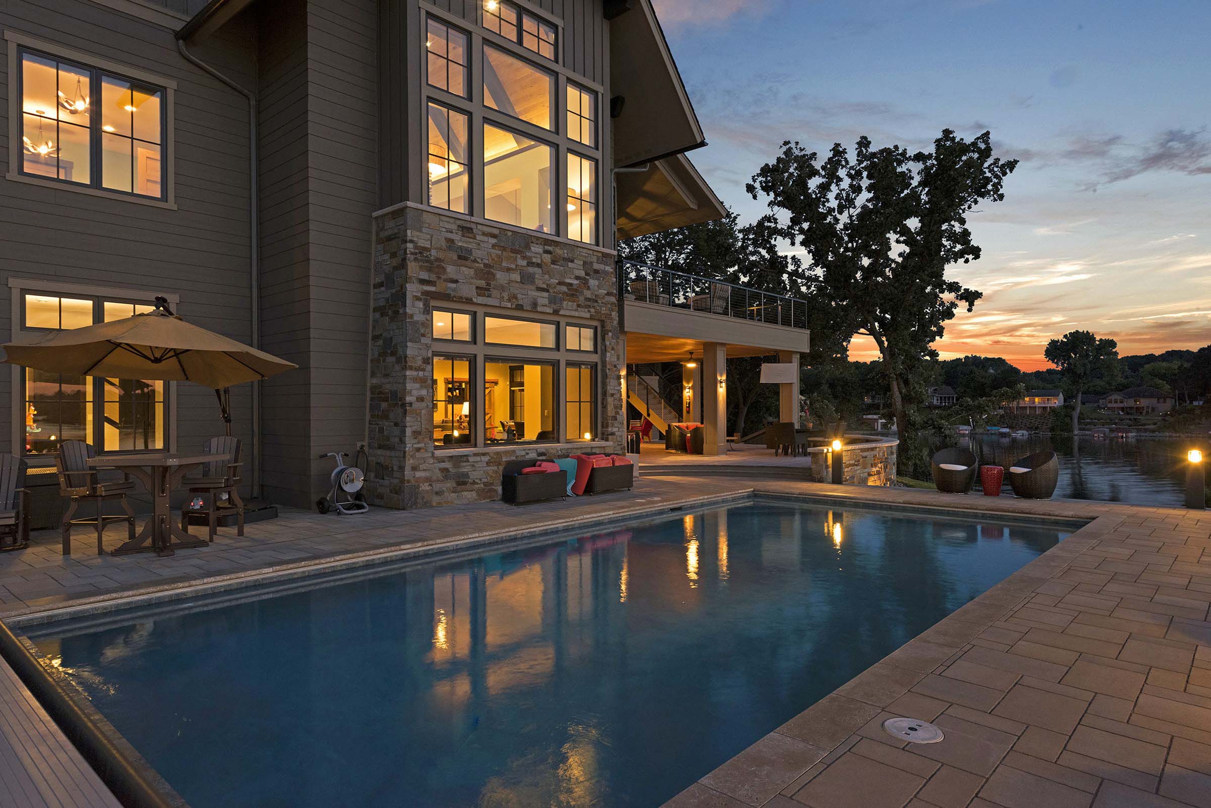 A mesmerizing home with a tranquil pool and inviting patio, enhanced by the tranquil beauty of dusk.