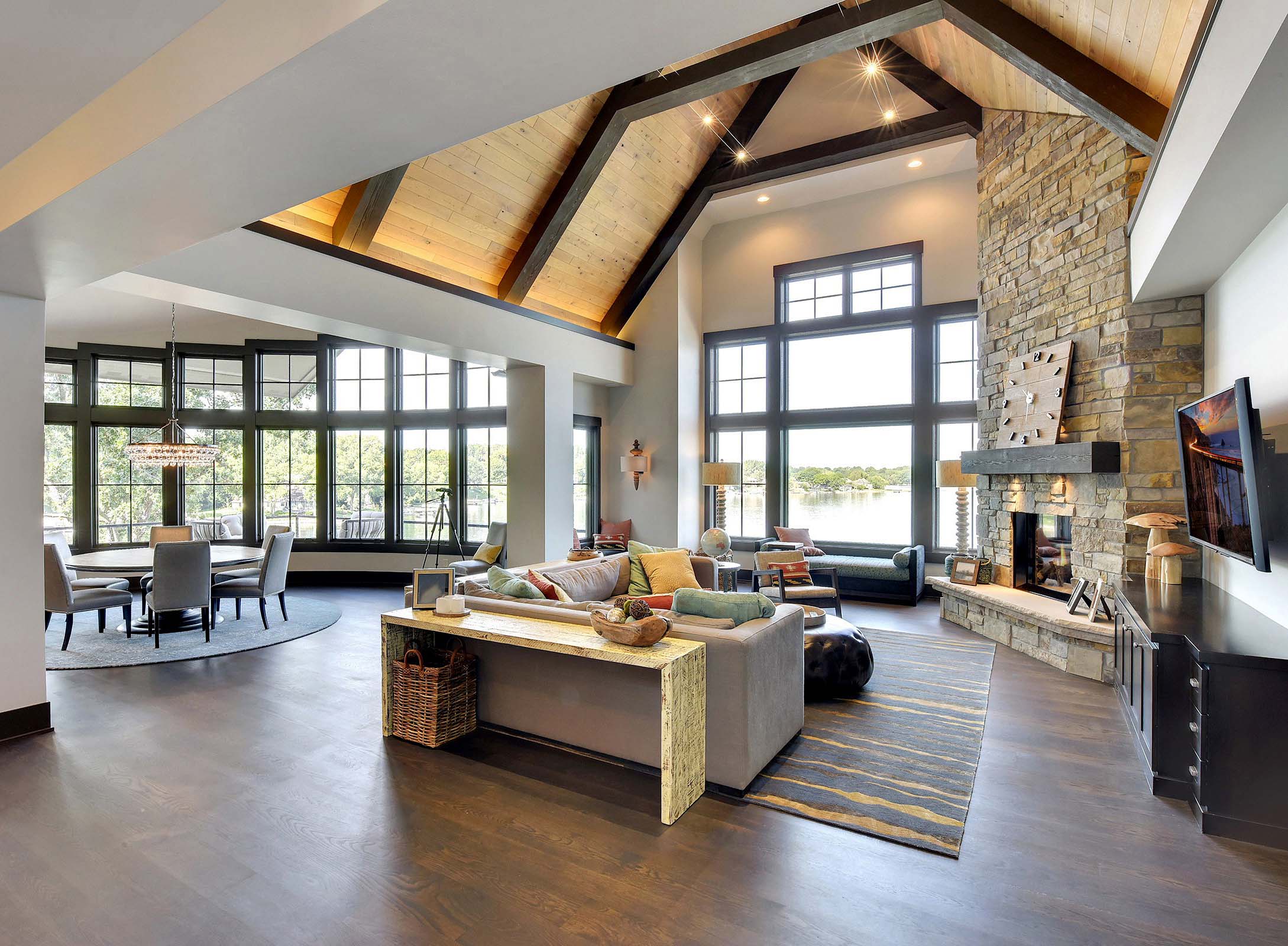 A large living room with wood beams and a fireplace.