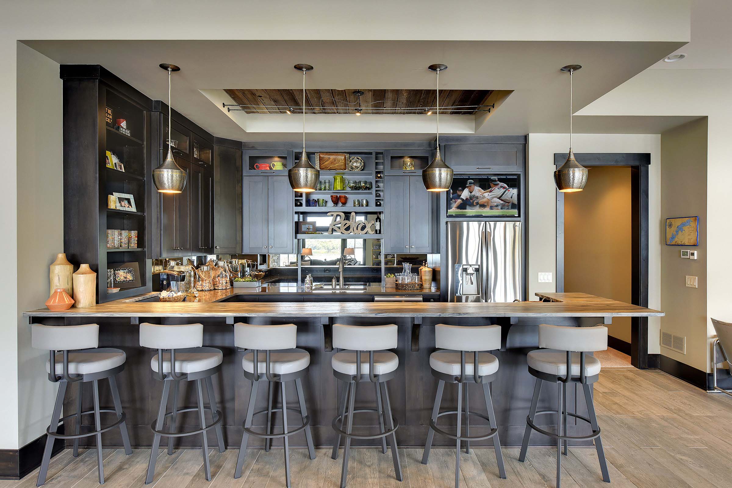 A kitchen with a bar and stools.