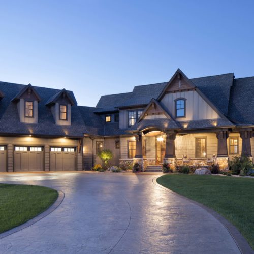 A beautiful home with a driveway and garage at dusk.