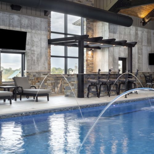 A large indoor swimming pool with a waterfall.
